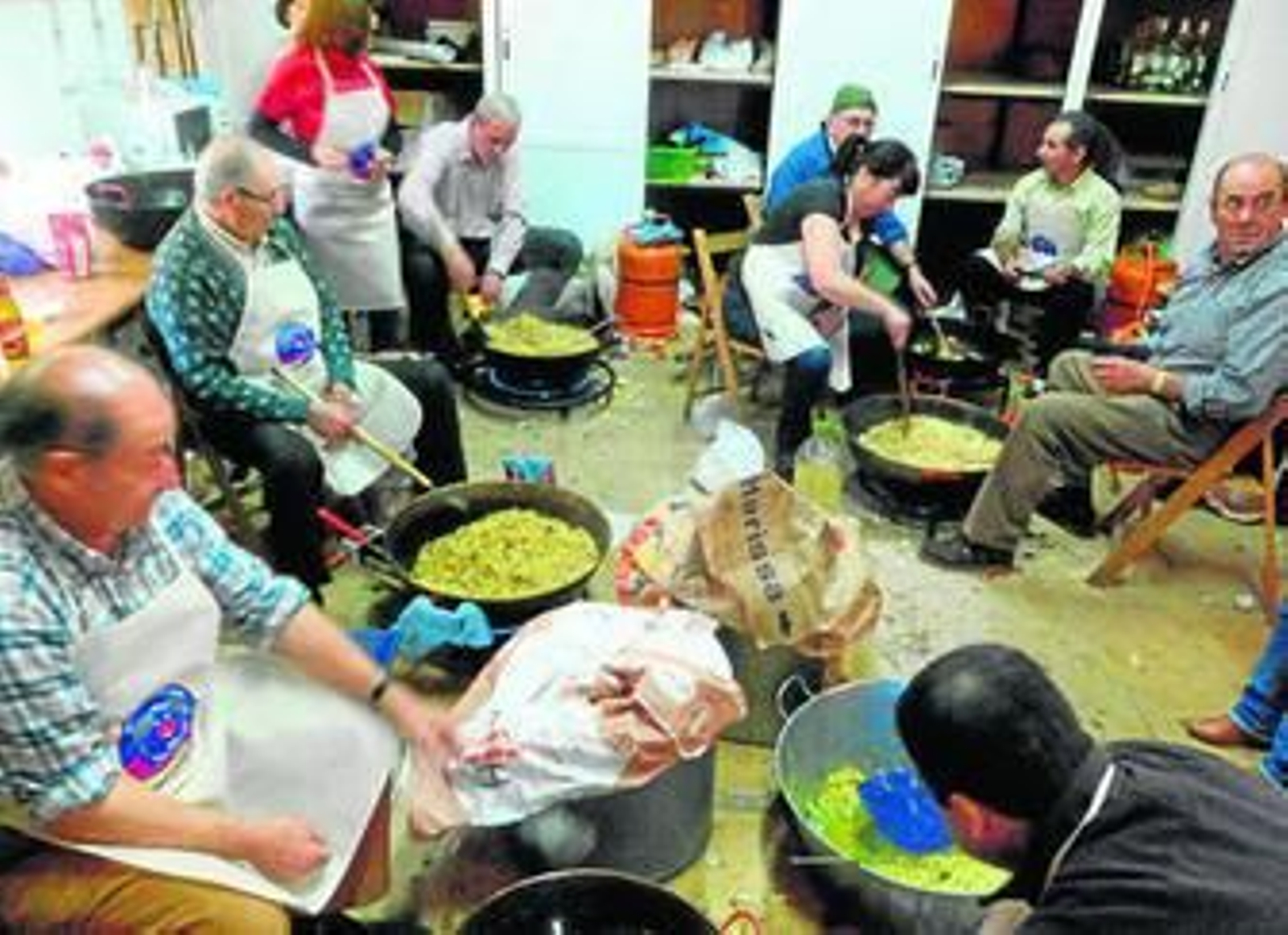 Un grupo de vecinos prepara las migas en la aldea de Aracena.