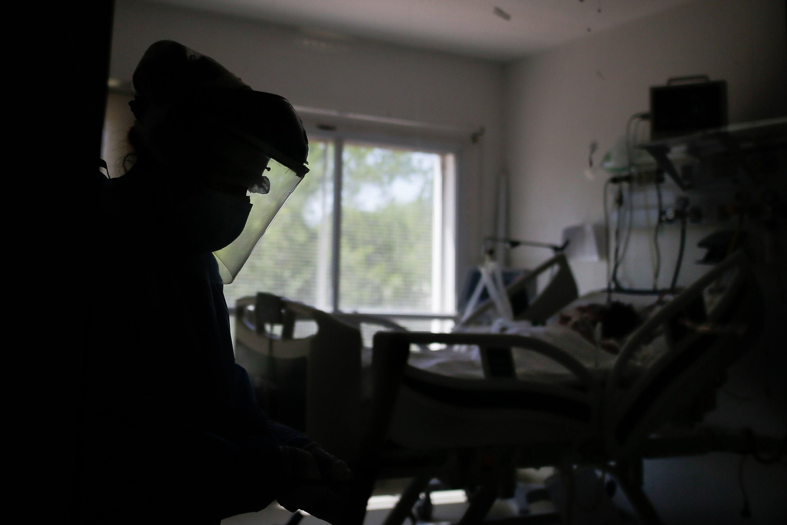 Un profesional sanitario observa a un paciente hospitalizado por covid-19.