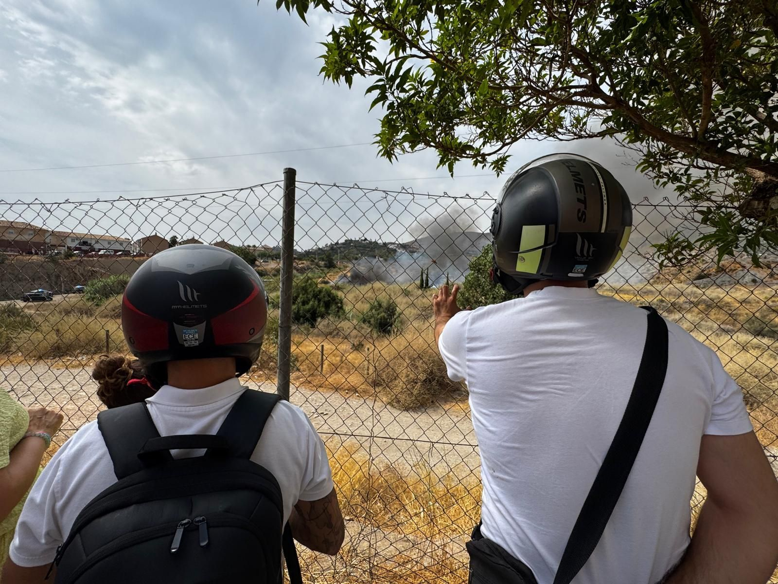 Varias personas observan la columna de humo a lo lejos