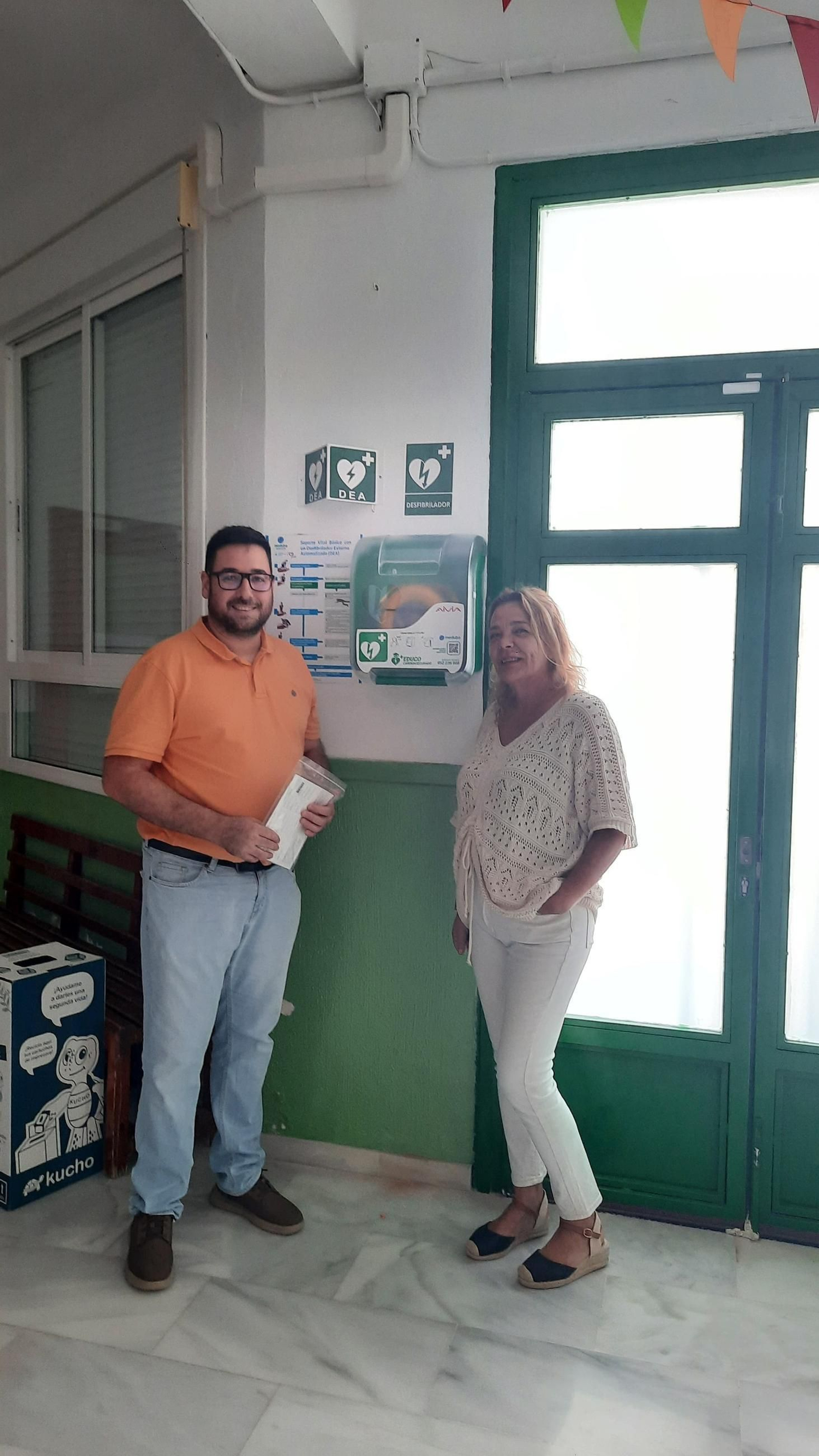 El alcalde con la directora del CEIP Virgen de las Angustias junto al nuevo desfibrilador.