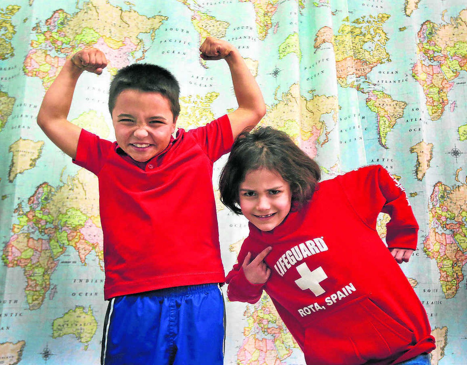 Ben y Aiden bromean ante un panel de mapas en su clase del colegio del poblado de Doña Blanca.