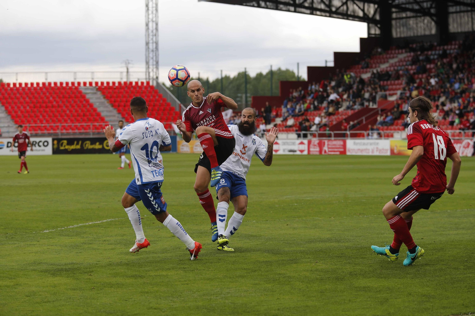 Javi Hervás trata de ganar un balón ante los jugadores del Tenerife Suso Santana y Marc Crosas.