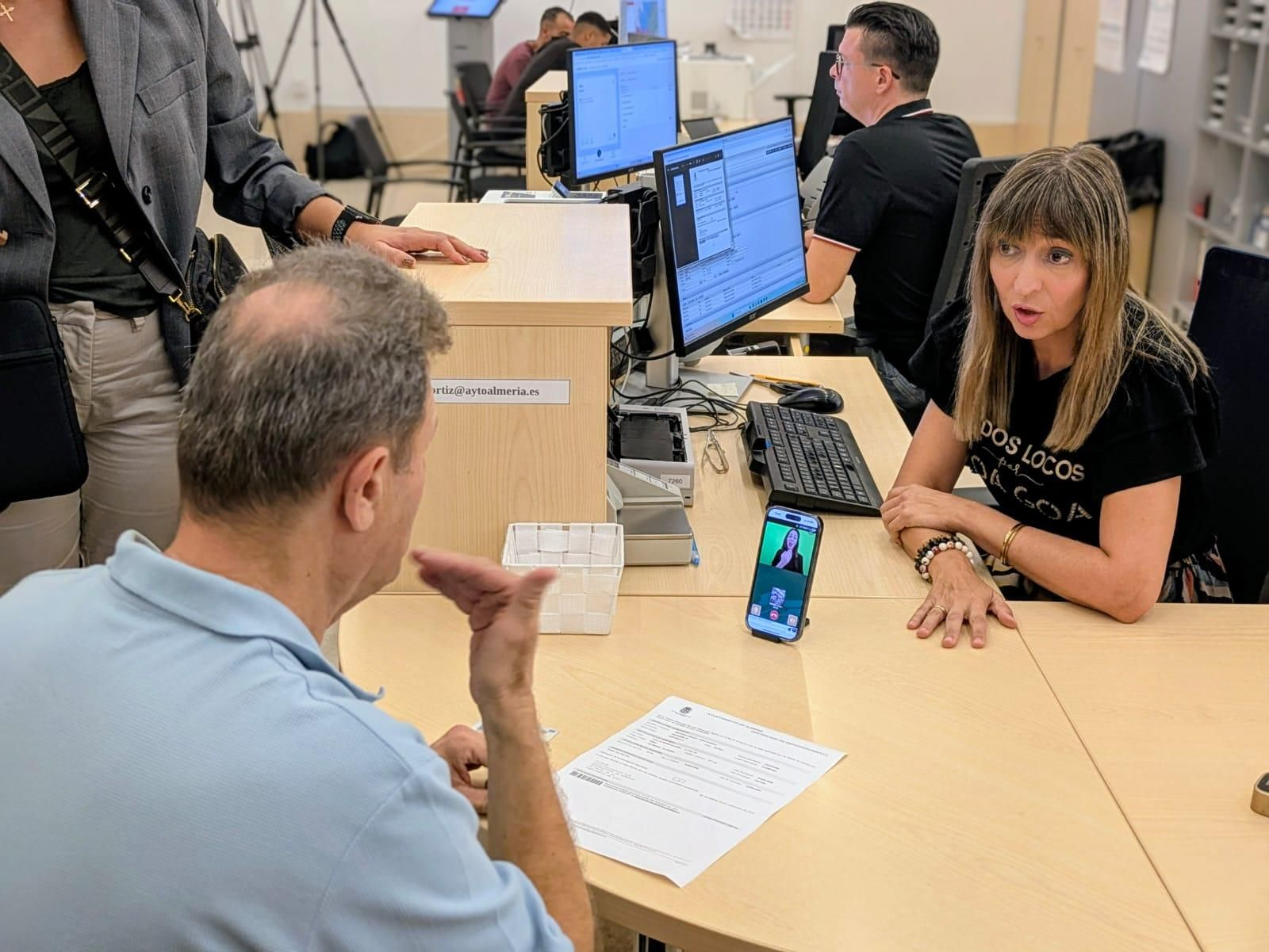 Una funcionaria atiende a una persona sorda que emplea el servicio de videollamada para ser interpretado