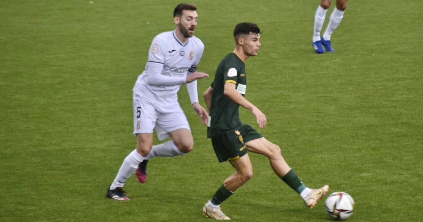 Luismi toca el balón ante la presión de David Castro, jugador del Ceuta.