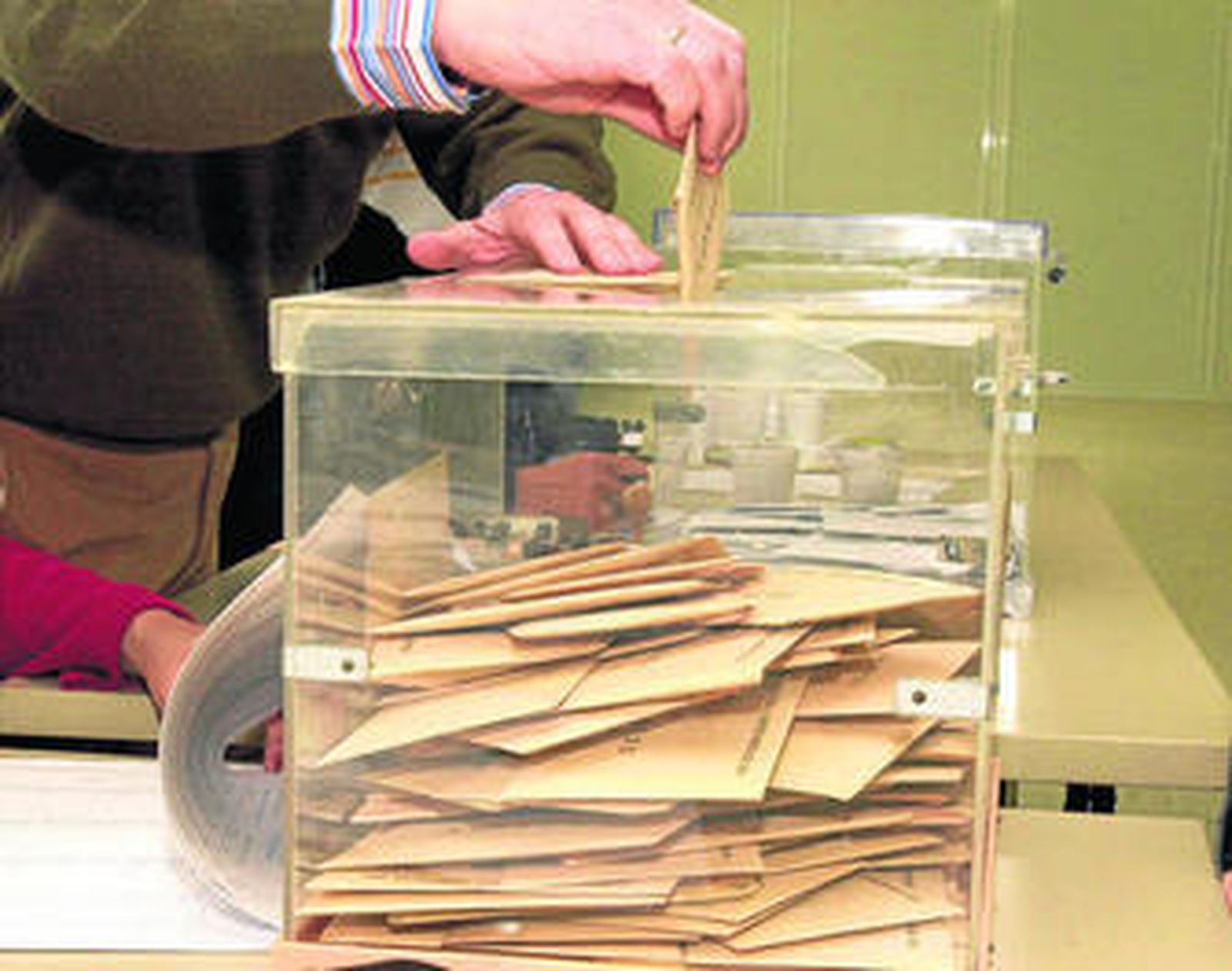 Un hombre deposita su voto en las urnas.