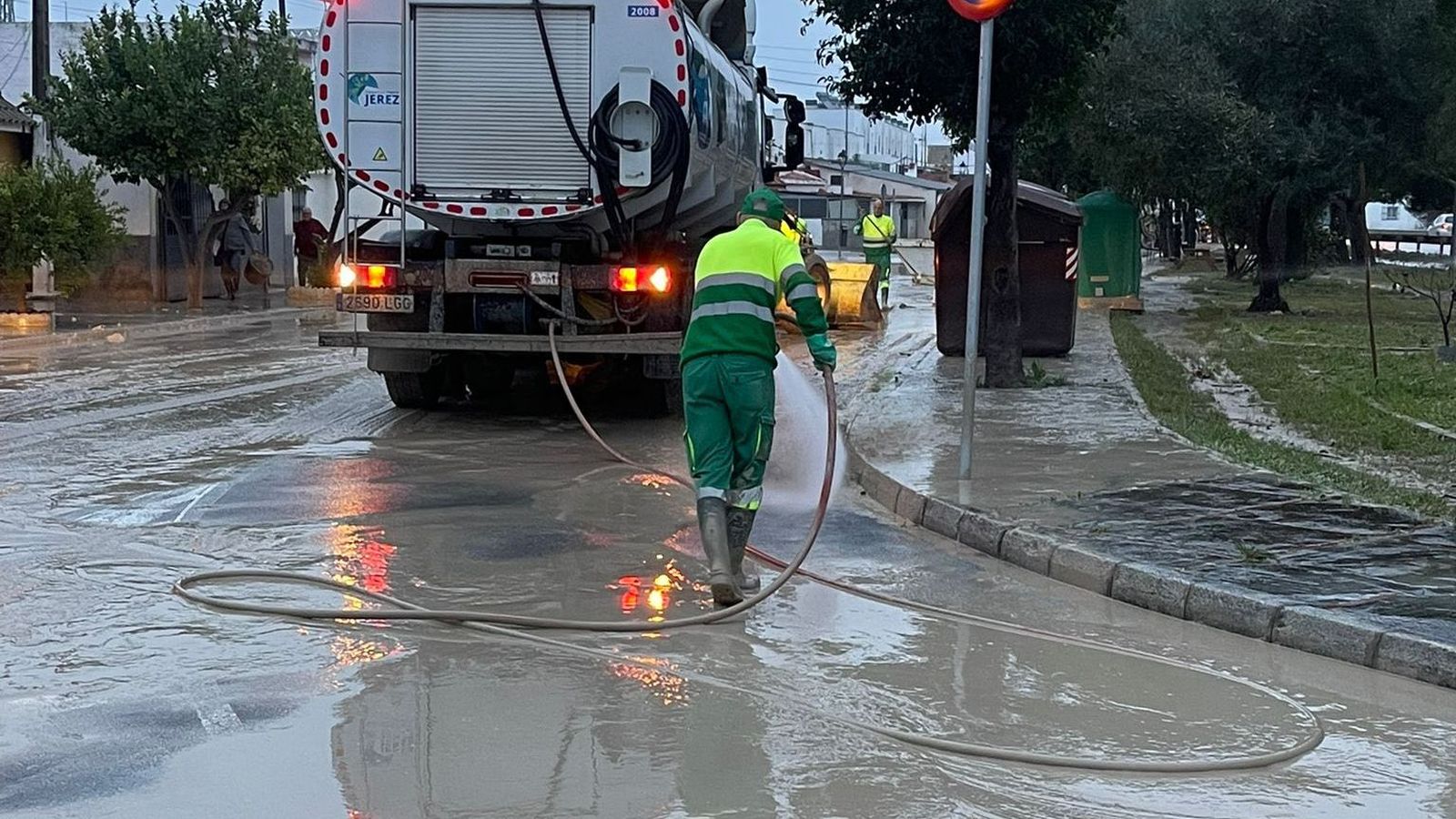 Operarios municipales retiran lodo en una de las zonas afectadas por la crecida del Guadalete.