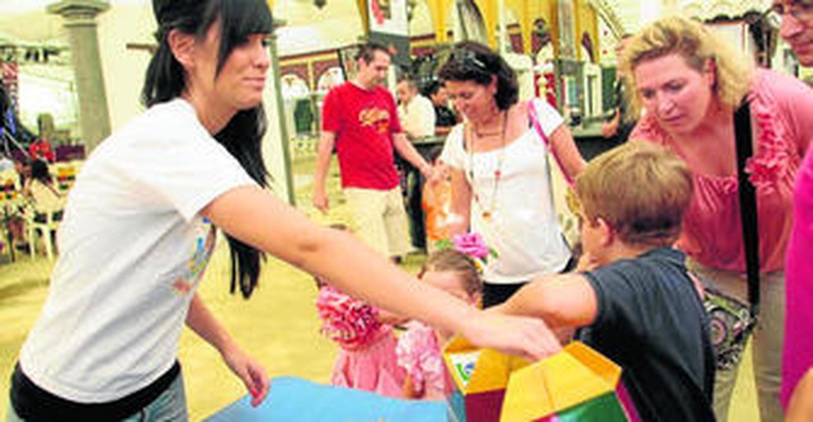 Los niños toman la merienda dentro de la caseta municipal.