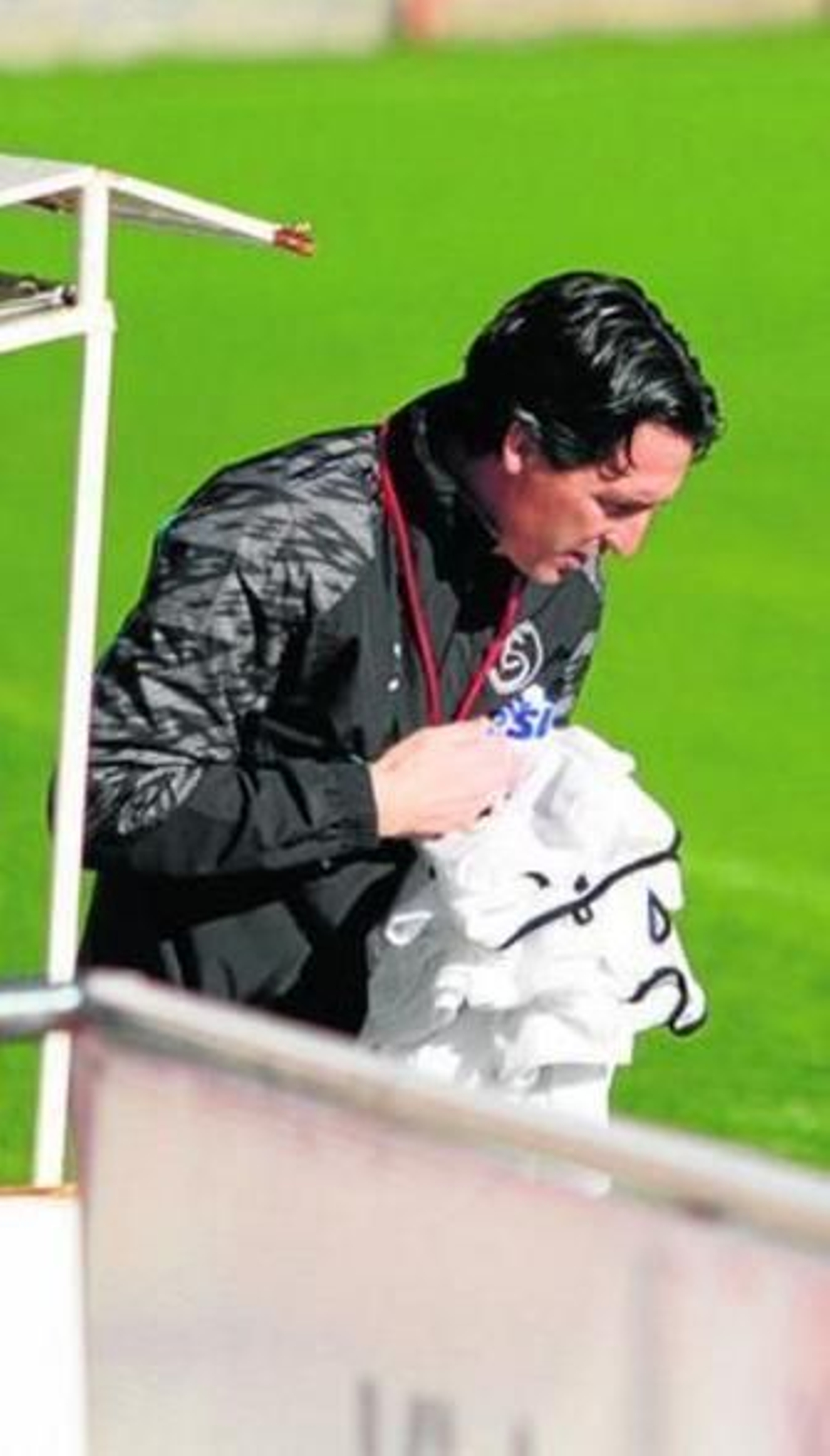 Unai Emery recoge unos petos del banquillo en una sesión.