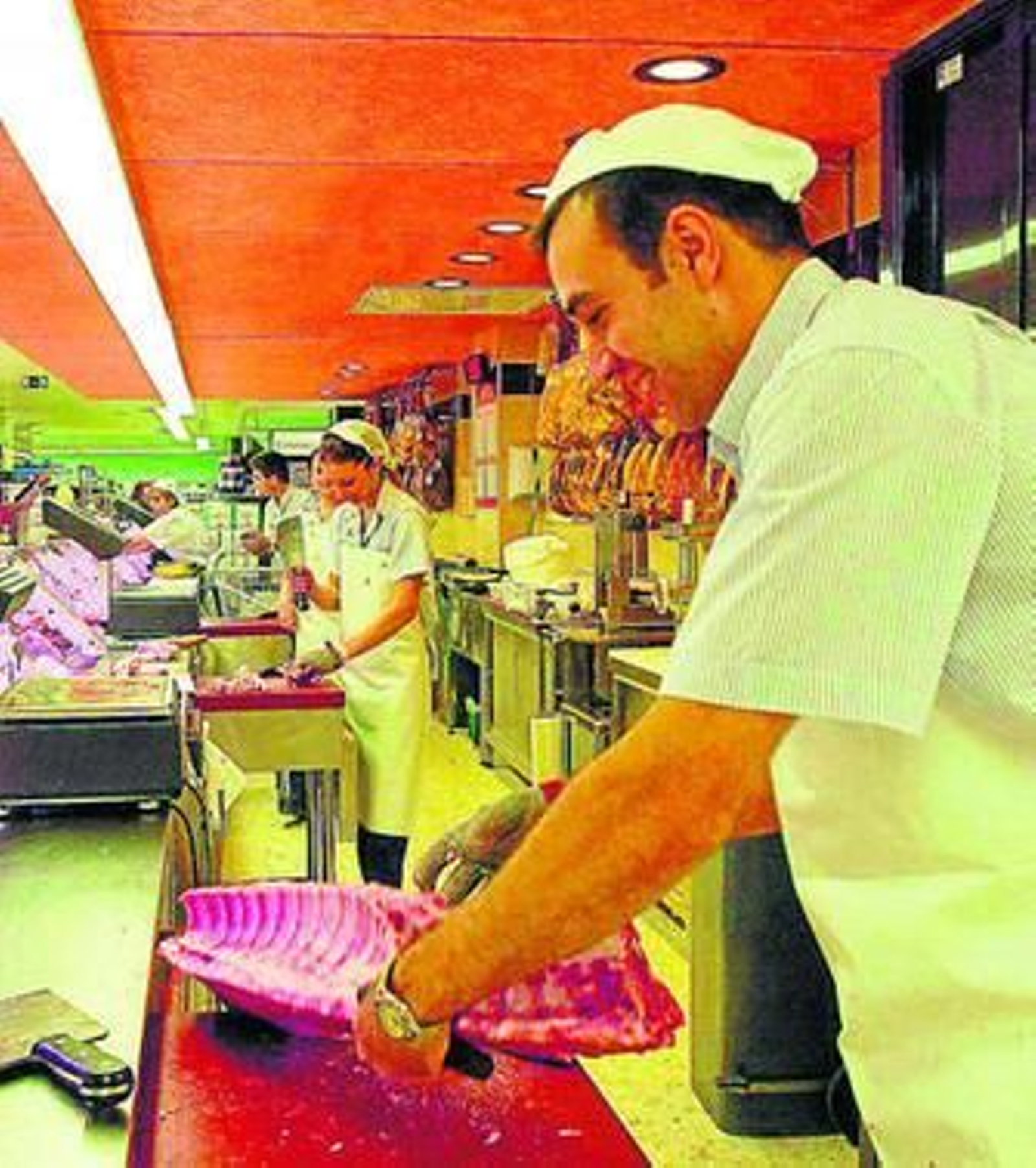 Varios carniceros trabajan en un supermercado.