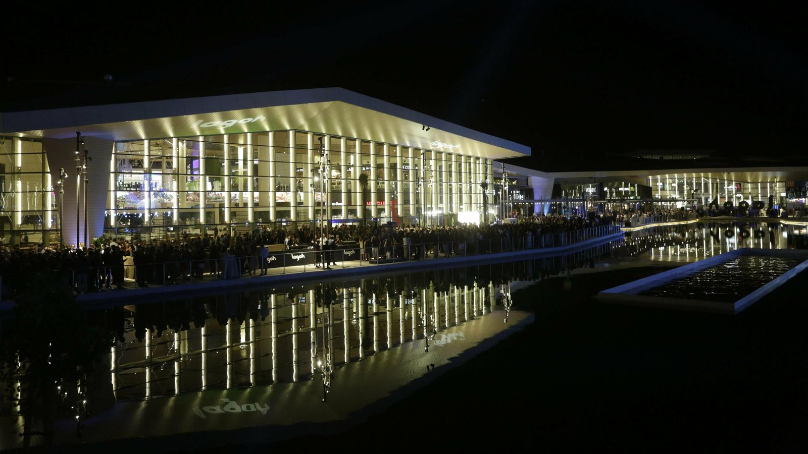 Vista de Lagoh por la noche con las luces sobre su cristalera y el reflejo en el lago central.