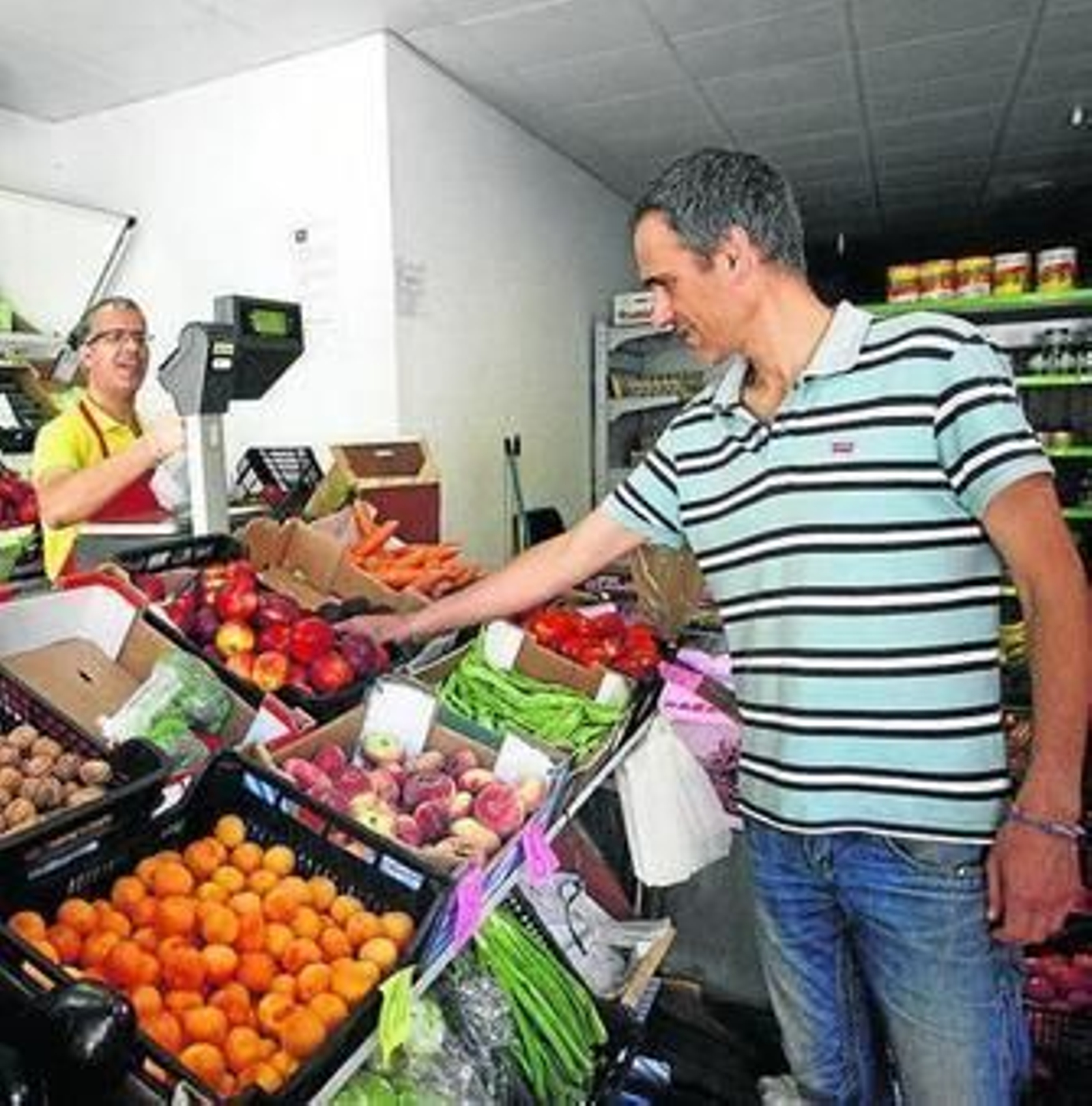 Un vecino de la popular barriada compra fruta en un comercio.