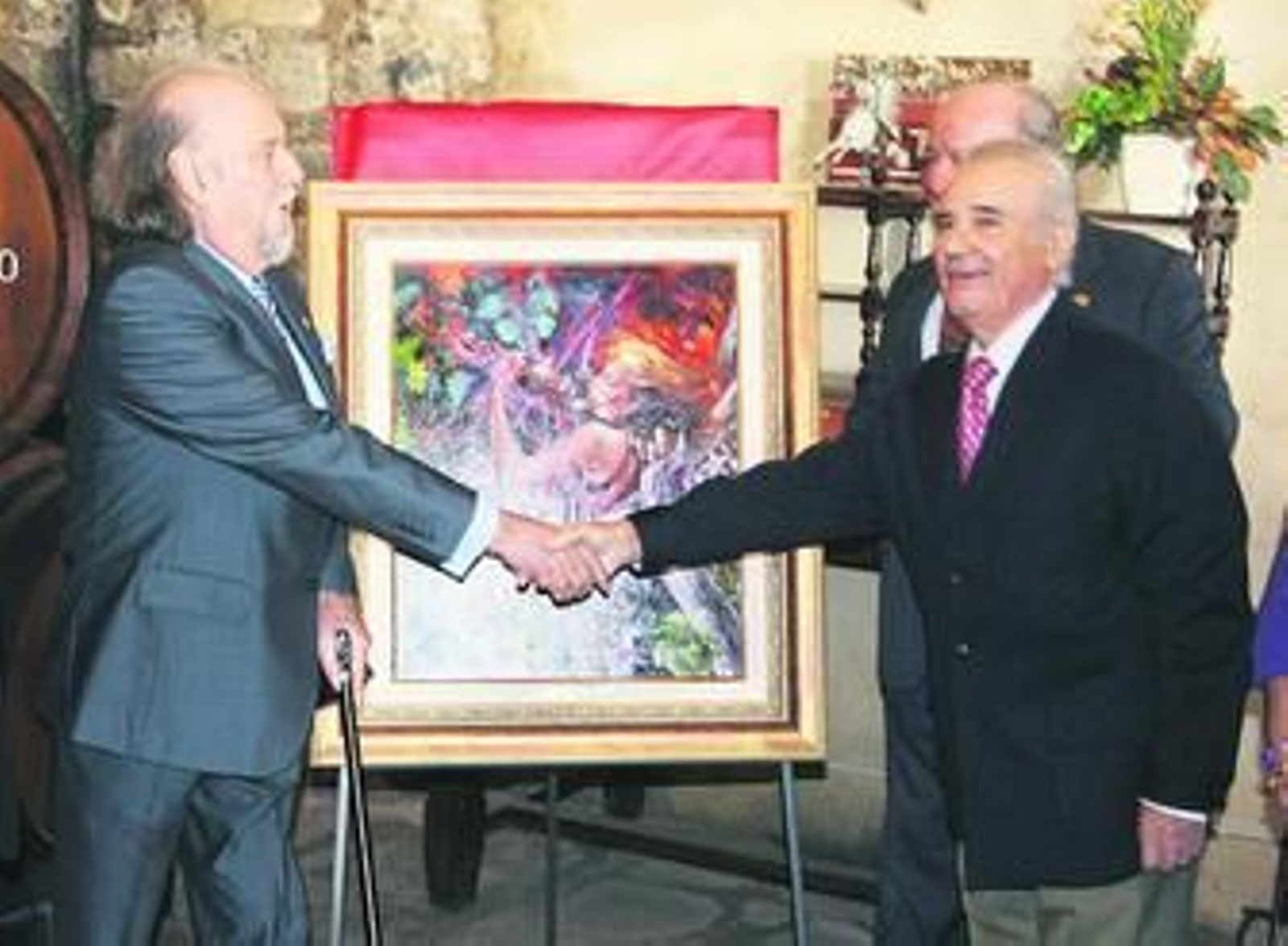 José Lorenzo Gallego, autor del óleo, estrecha la mano del presidente de Cáritas, Juan de los Ríos