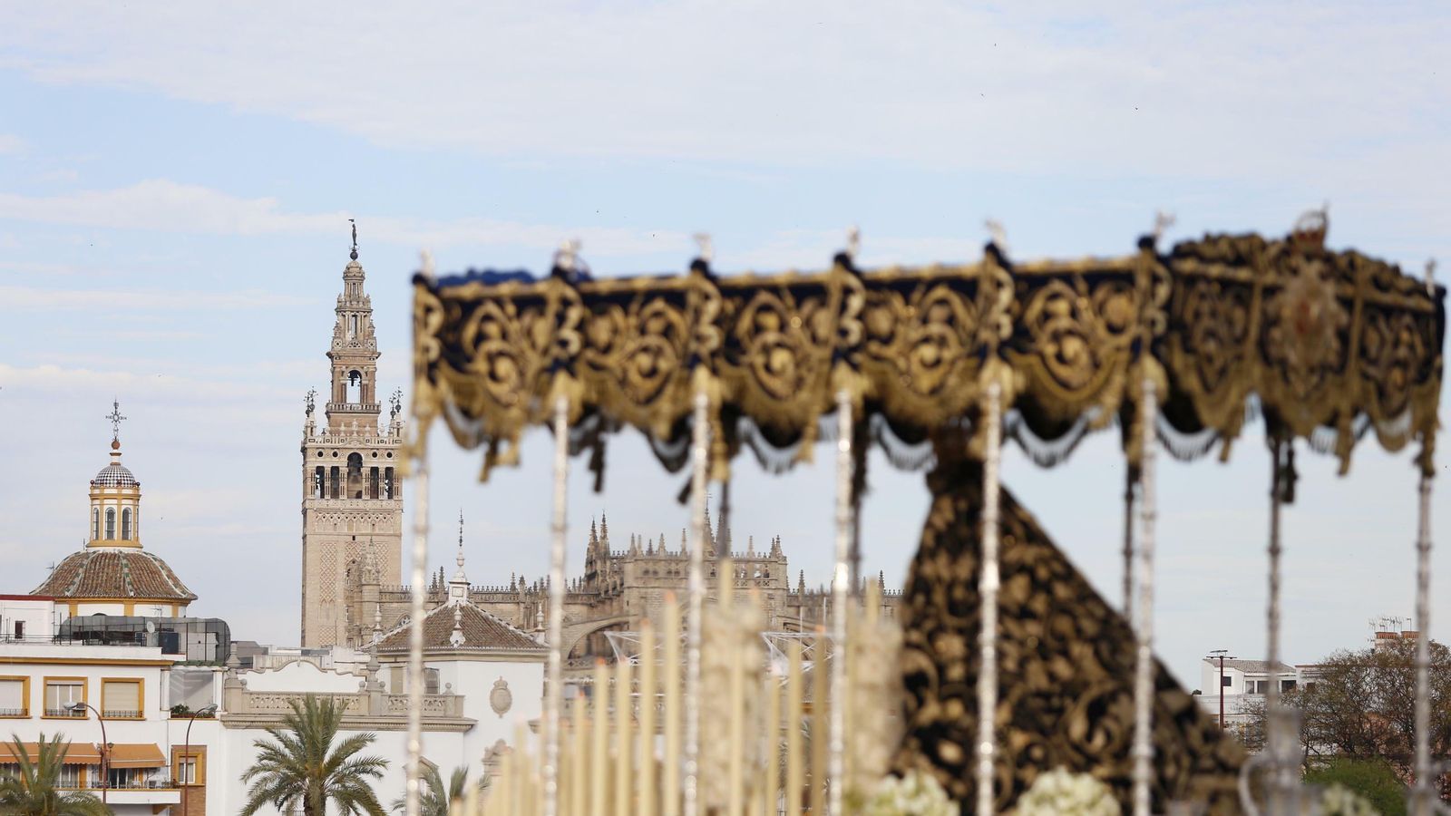 El palio de la Estrella por el Puente de Triana con la Catedral al fondo