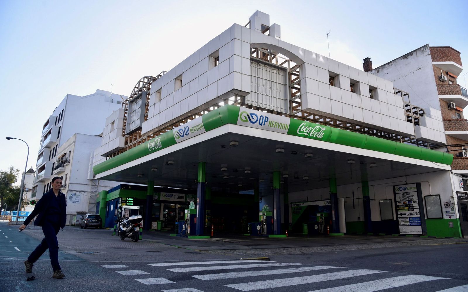 Una mujer camina a la altura de la gasolinera de Luis Montoto.