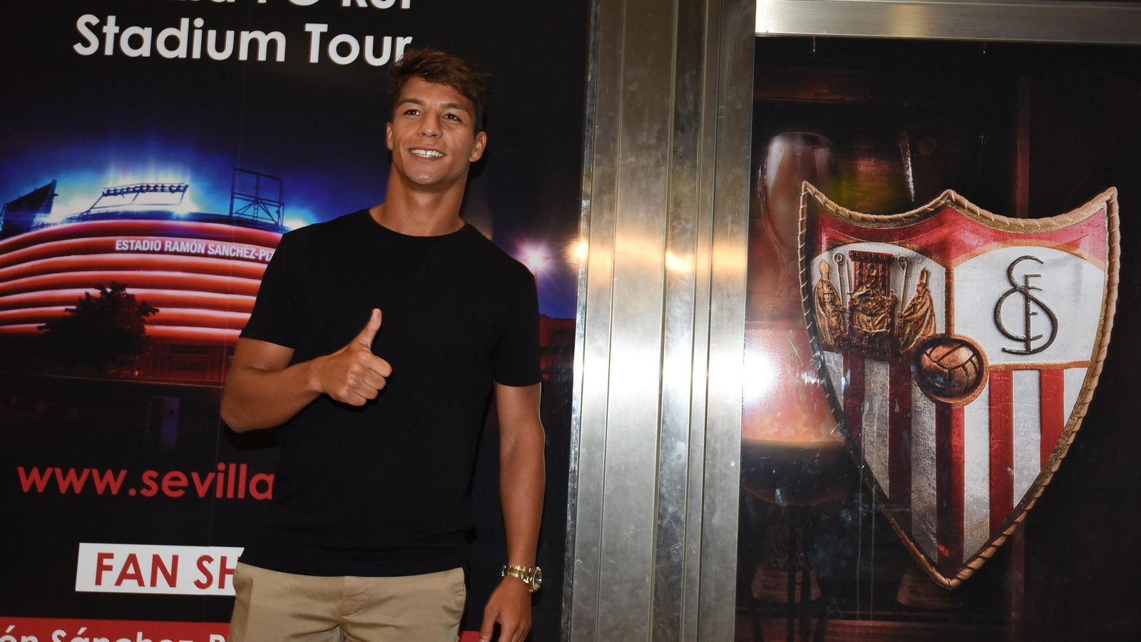 Óliver Torres posa junto al escudo del Sevilla FC