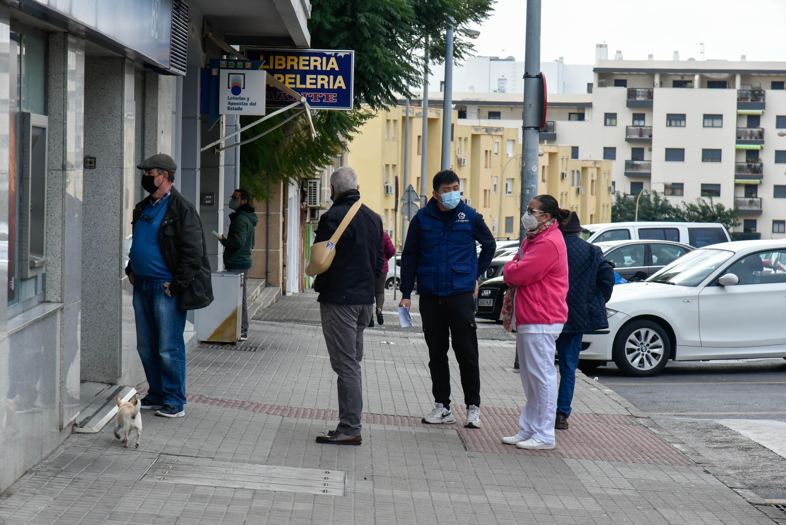 Varias personas hacen cola para acceder a un establecimiento en Algeciras.