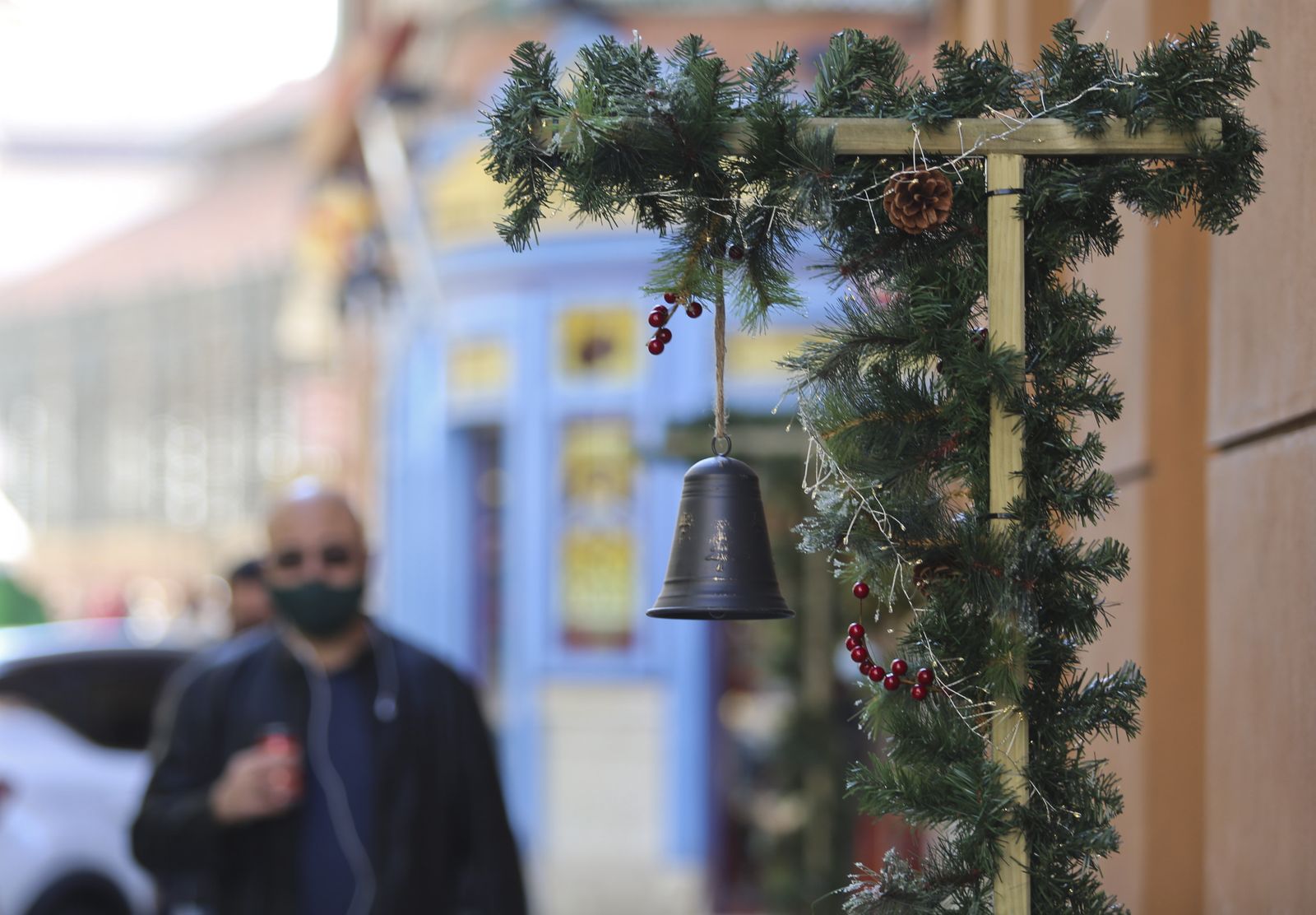 Un hombre pasa por delante de un comercio con decoración navideña en Málaga.