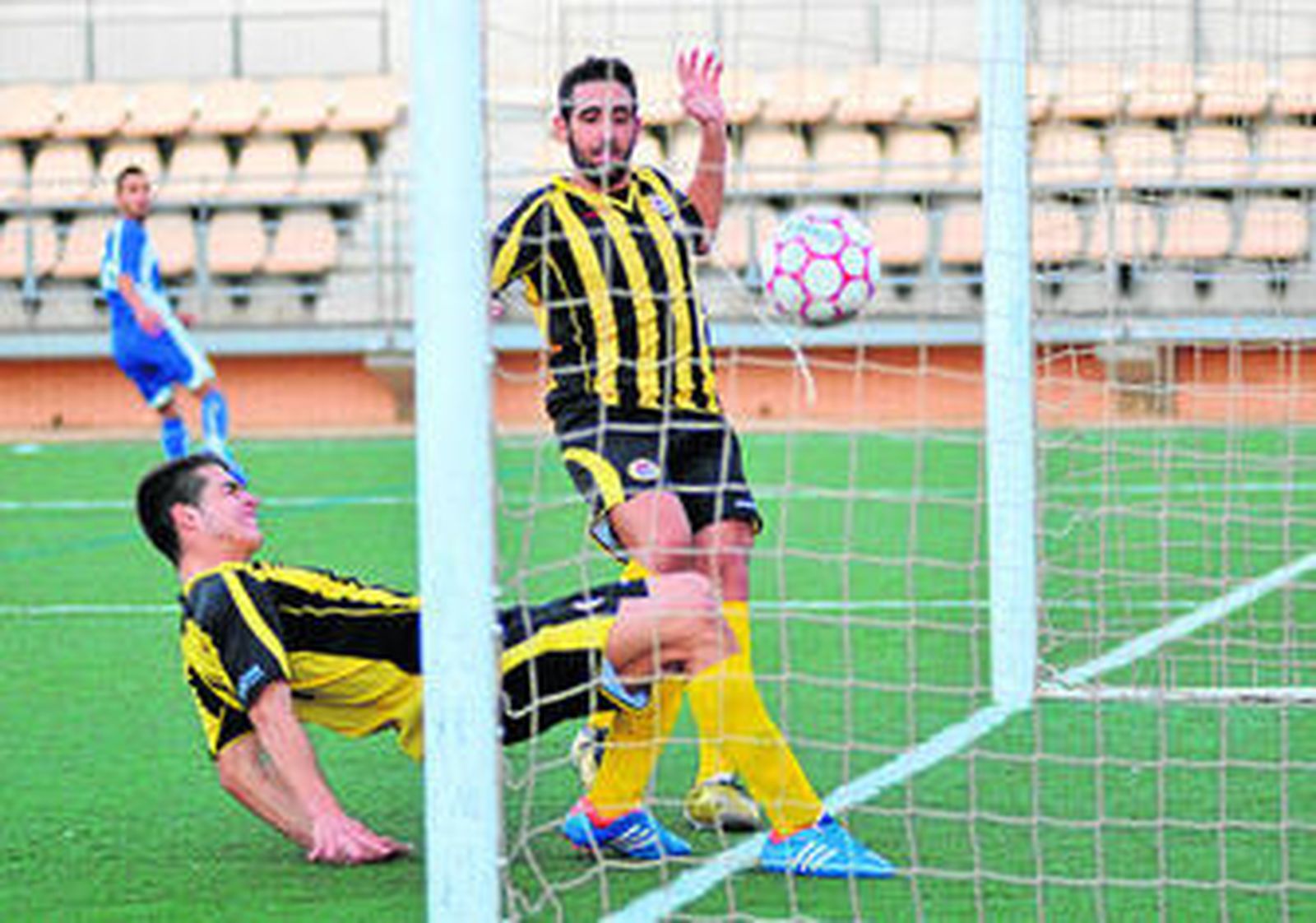 Dos jugadores del Bazán no pueden evitar que el balón entre en su portería, durante el choque de ayer.