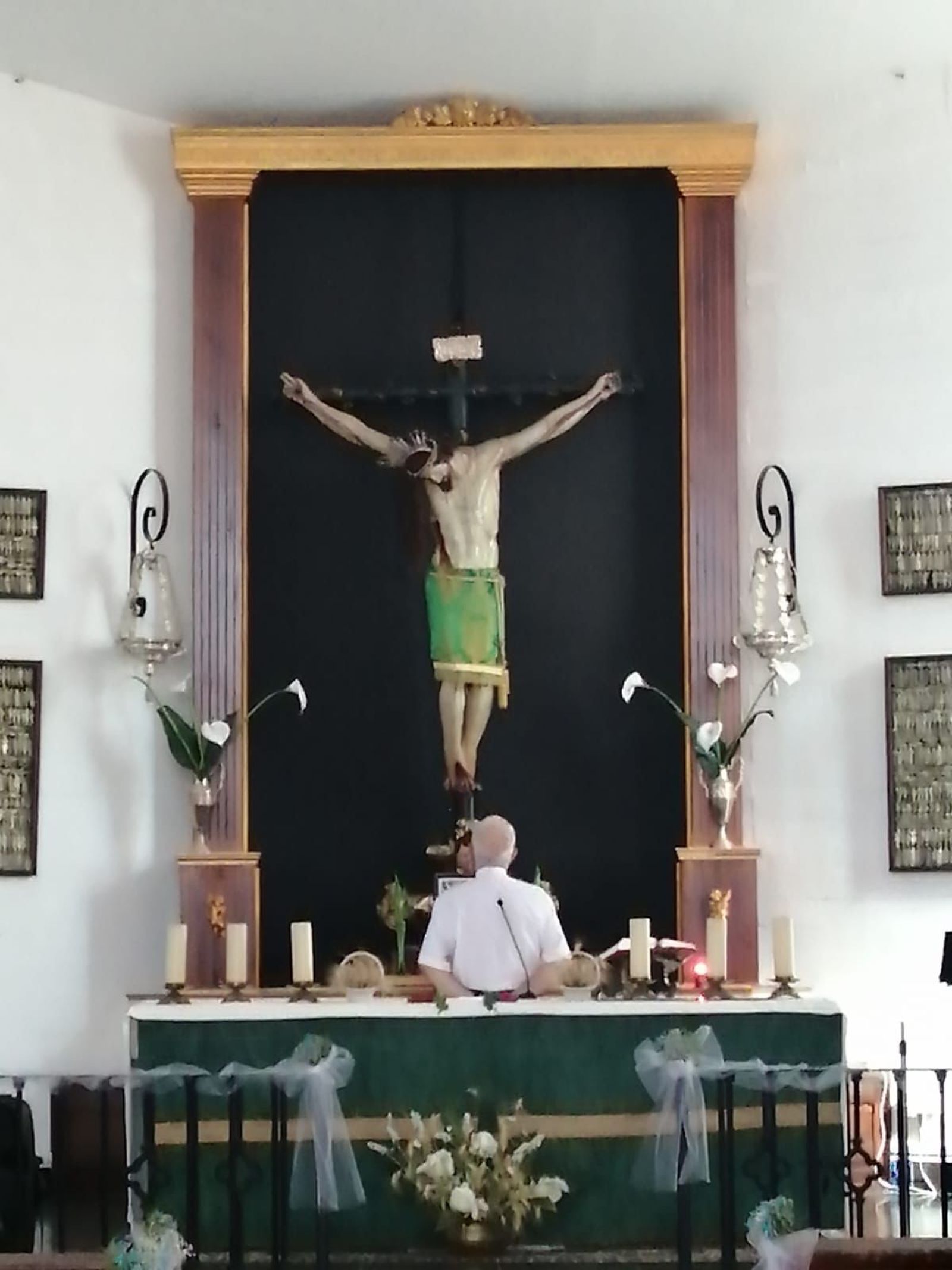 El cura Paco a los pies del Cristo de La Almoraima.