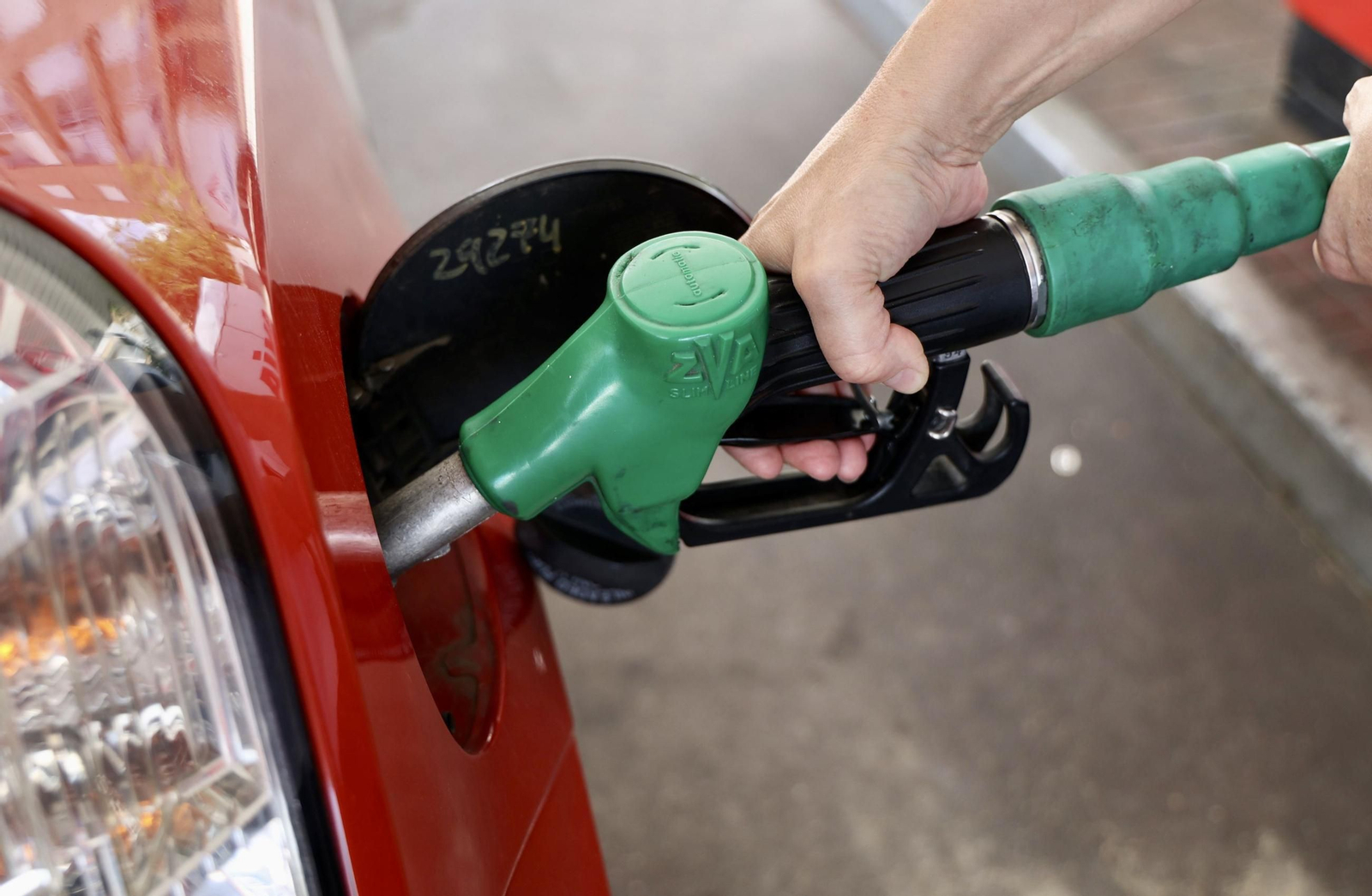 Una persona llena el  depósito  de su coche con gasolina.