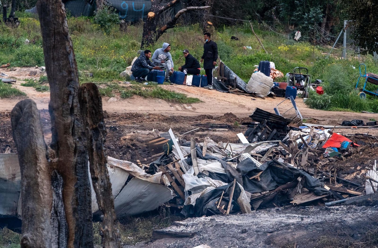 Un grupo de personas observa el estado en el que quedó el asentamiento incendiado el viernes.