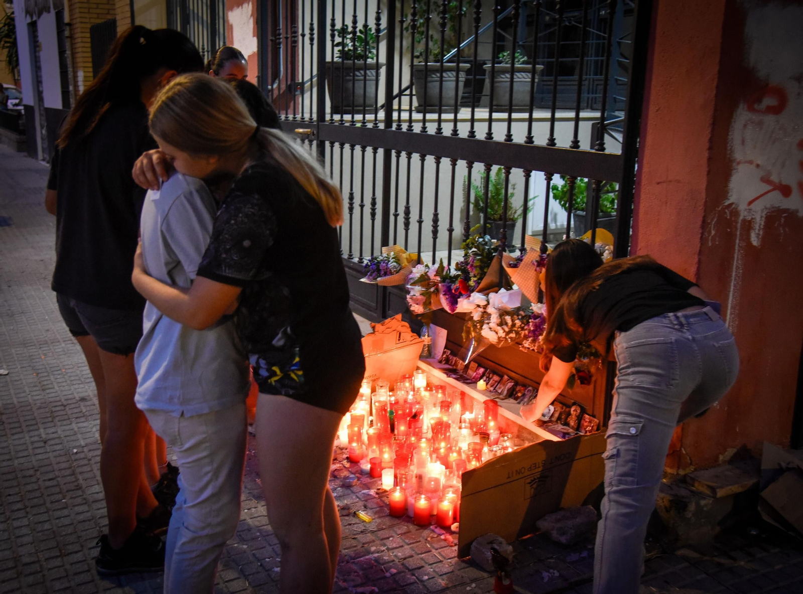 Varias alumnas se abrazan ante el altar en memoria de Sandra Peña.