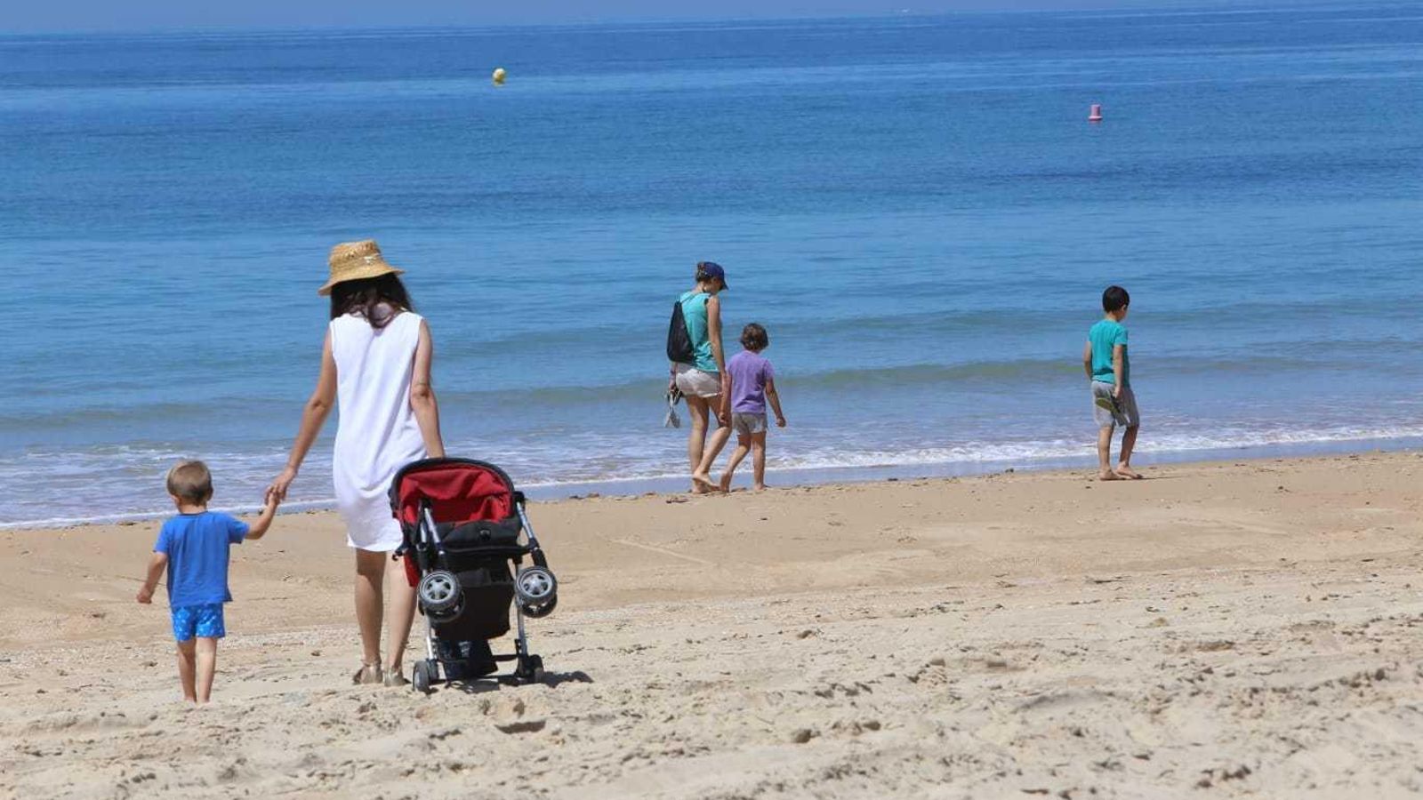 Varias personas caminan por la playa de La Barrosa Varias personas caminan por la playa de La Barrosa