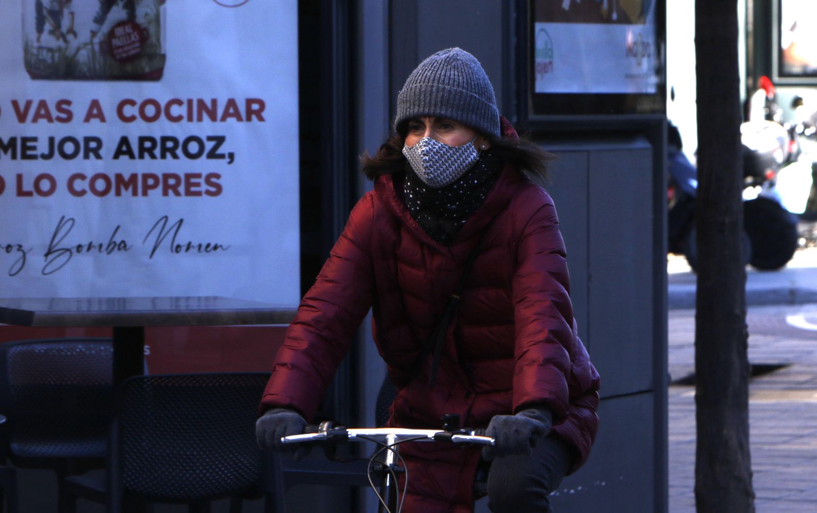 Una joven en bicicleta protegida del frío.