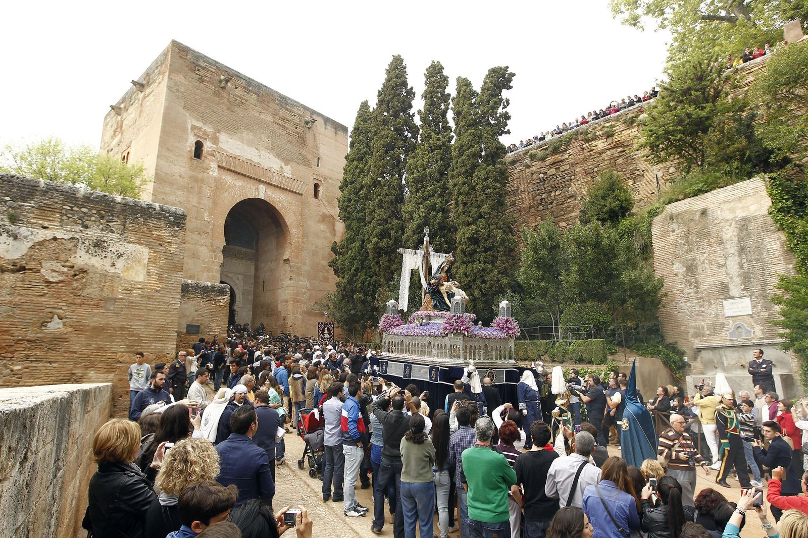 Locales y turistas viviendo la salida de Santa María de la Alhambra a las afueras del monumento