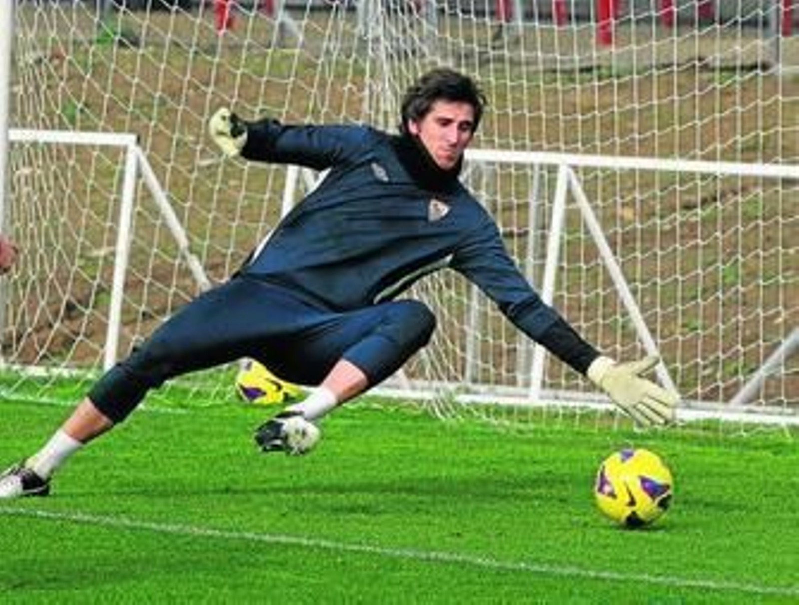 Julián se tira abajo para atajar un balón en la sesión matinal de ayer.