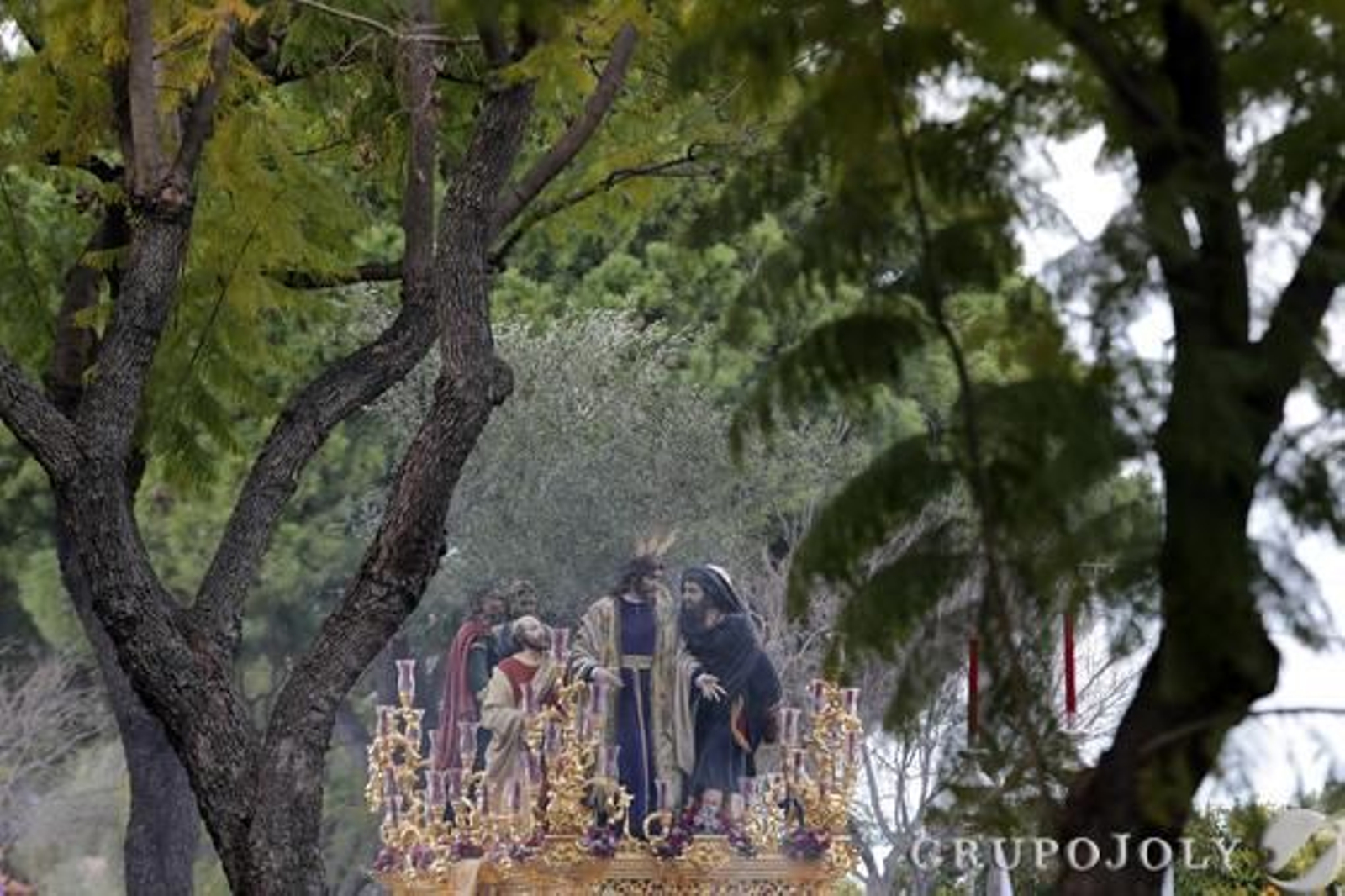 Estampa del misterio de La Clemencia, enmarcado entre árboles, a su llegada a la calle Doctor Fleming y buscando la Carrera Oficial.

Foto: Manuel Aranda