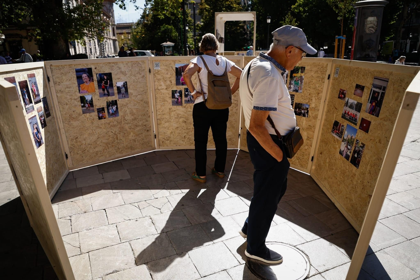 Dos visitantes contemplan las imágenes de dos paneles expositivos.