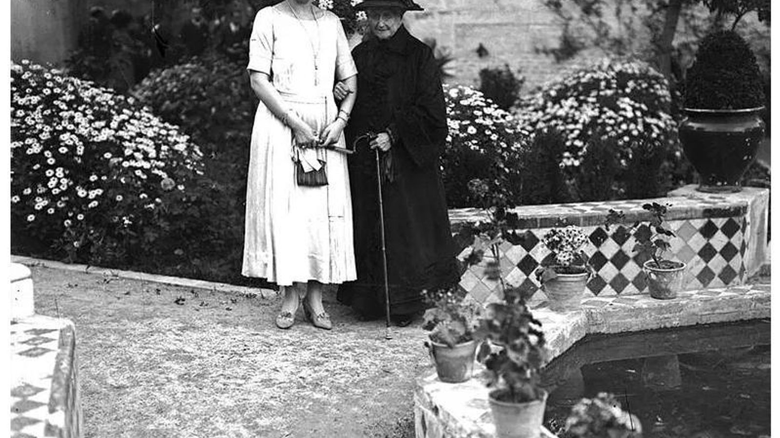 Fotografía tomada en el año 1920 en Las Dueñas, en Sevilla. En ella  aparece la emperatriz Eugenia de Montijo, dos meses antes de morir en el Palacio de Liria, en los jardines de la residencia de los Alba, que frecuentaba en esa época, junto a la Reina Victoria Eugenia.