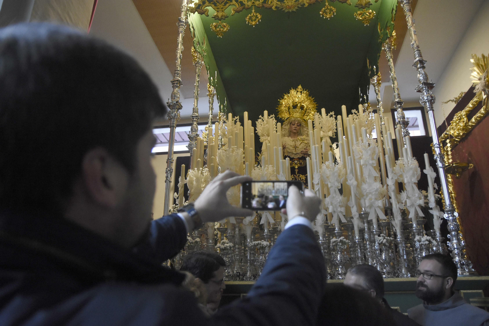 Un joven fotografía con el movil al paso de palio de María Santísima de la Esperanza del Valle. Un joven fotografía con el movil al paso de palio de María Santísima de la Esperanza del Valle.