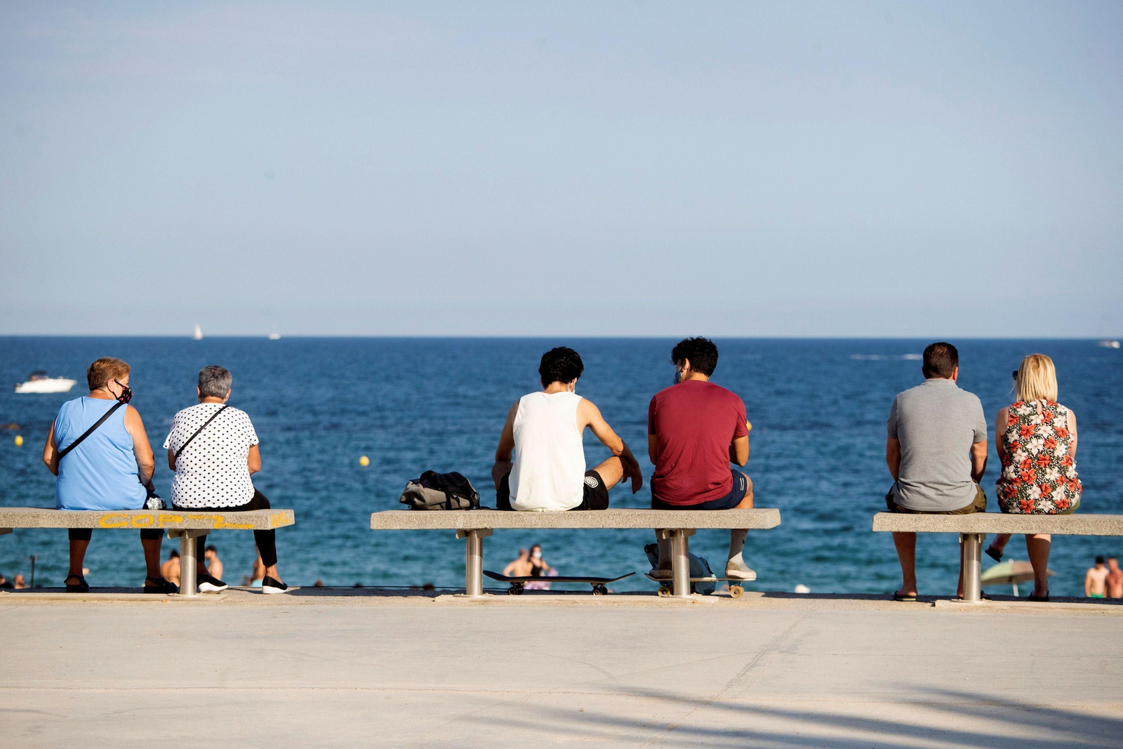 Gente en los bancos de una playa en Cataluña.
