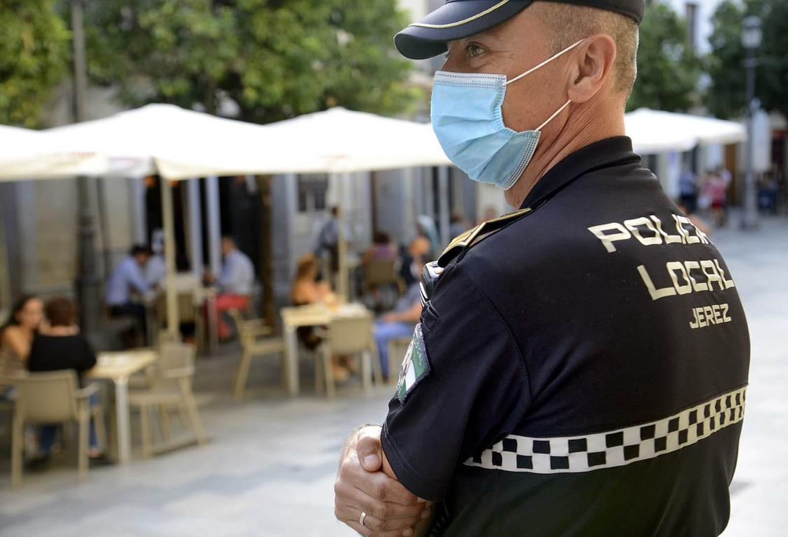 Un policía local junto a una terraza antes del actual cierre de la actividad no esencial en Jerez.
