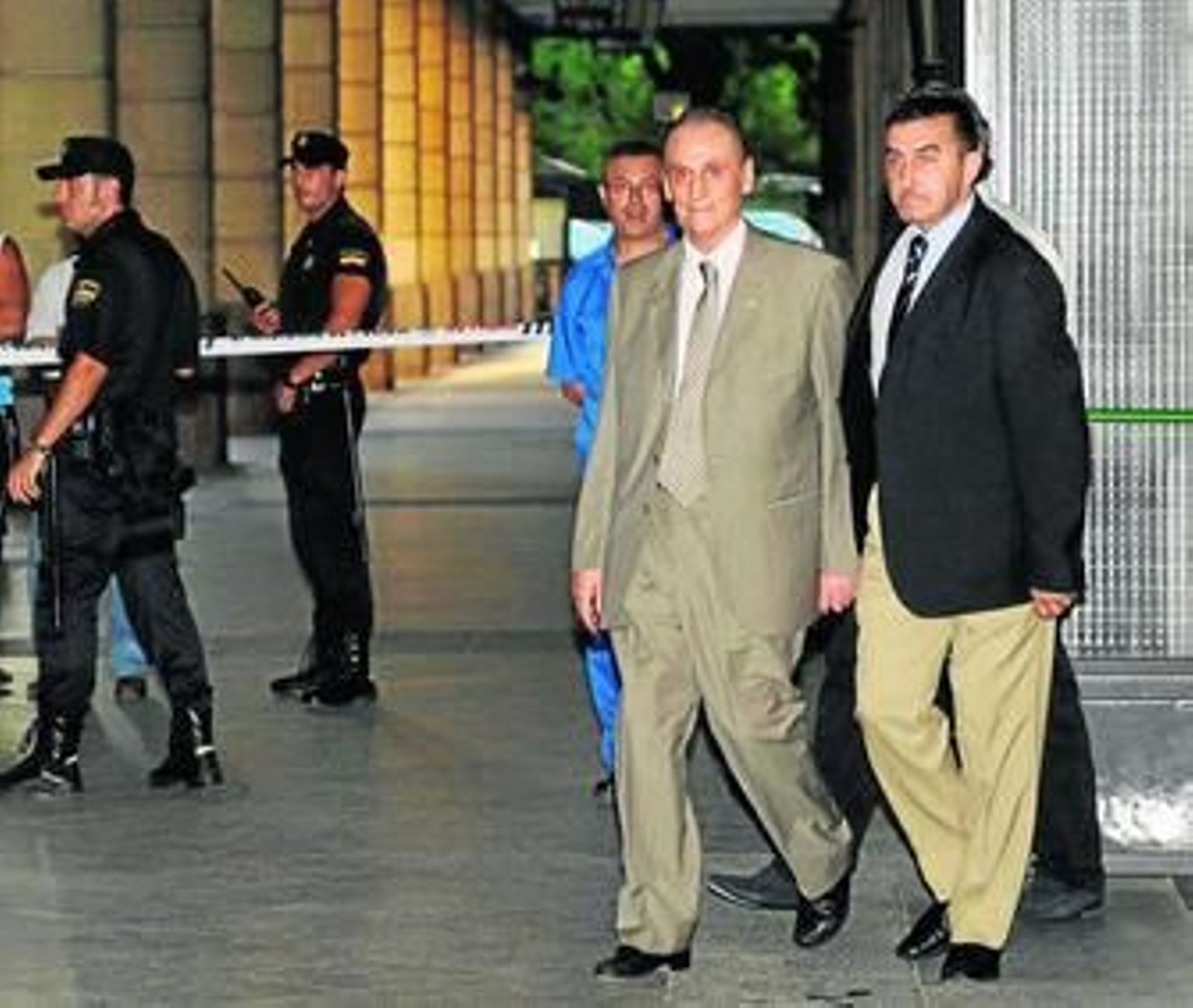 Lopera sale de los juzgados acompañado por uno de sus guardaespaldas.