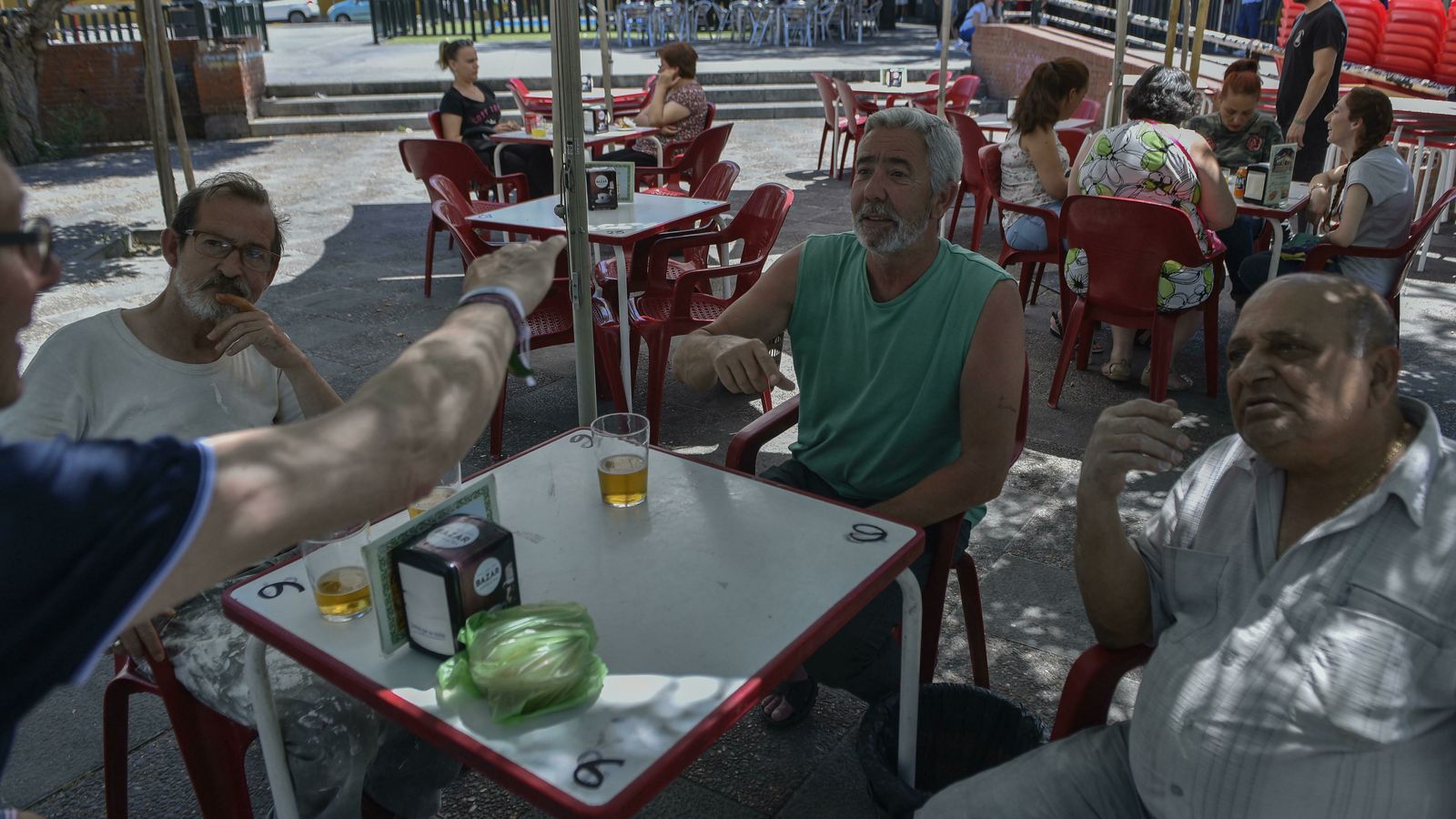José Luis, Antonio y Paco charlan en un velador de la Plaza de la Candelaria.