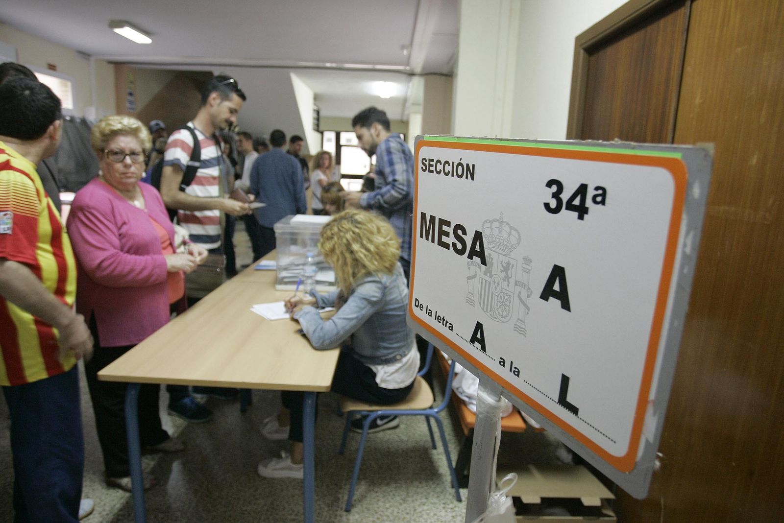 Personas ejerciendo su derecho a voto en un colegio electoral