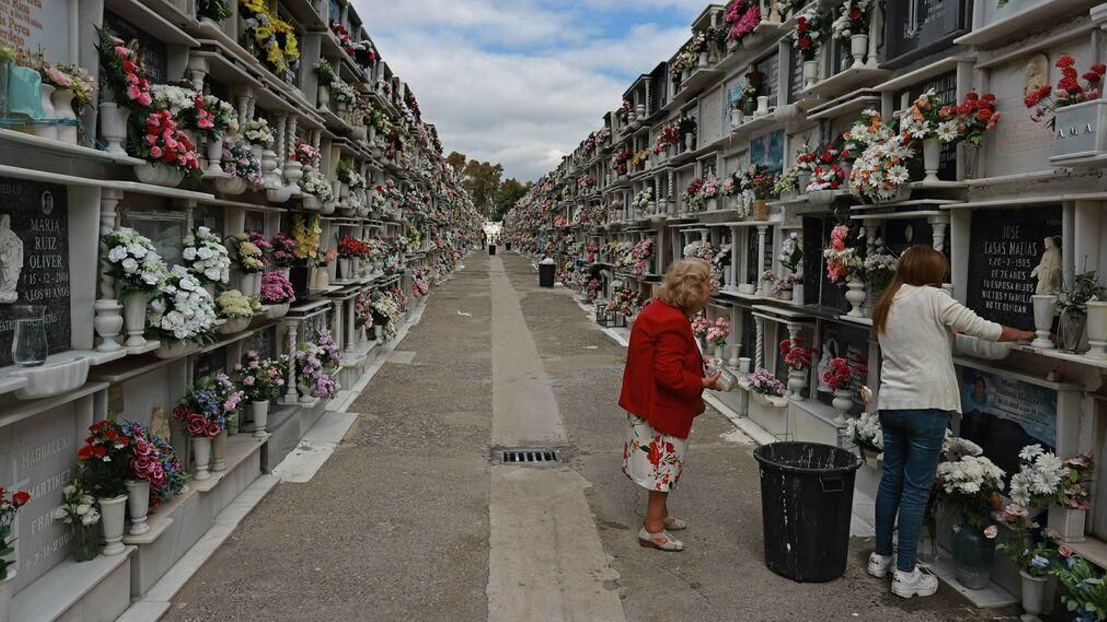 Dos mujeres adecentan un nicho en el cementerio viejo de Algeciras.