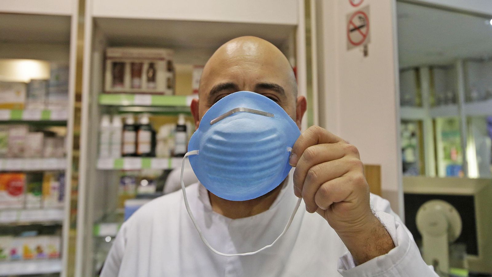 Farmacéutico sostiene una máscarilla. Farmacéutico sostiene una máscarilla.