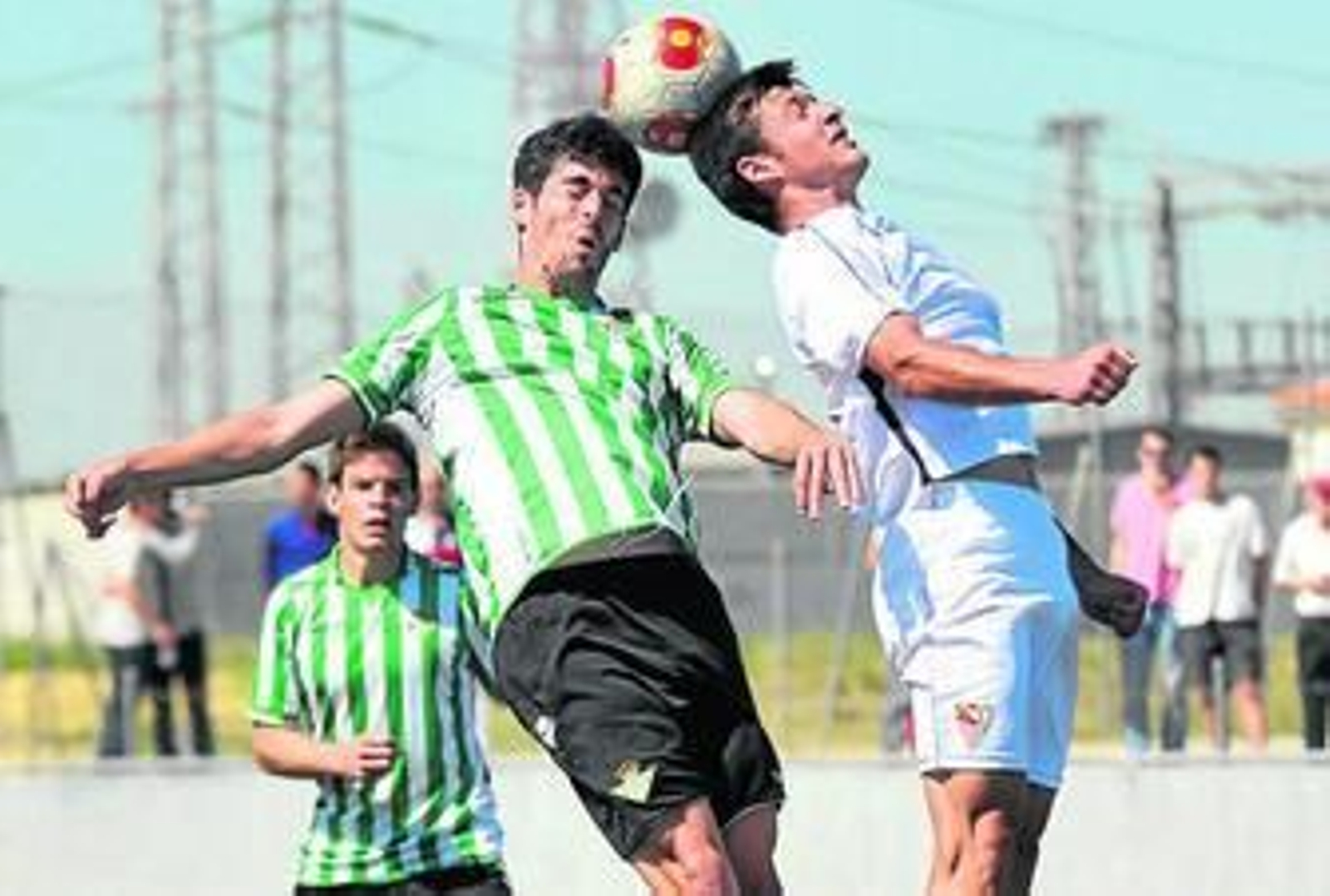 El central del Betis B Caro salta con el atacante del Sevilla C José, en un lance del partido.
