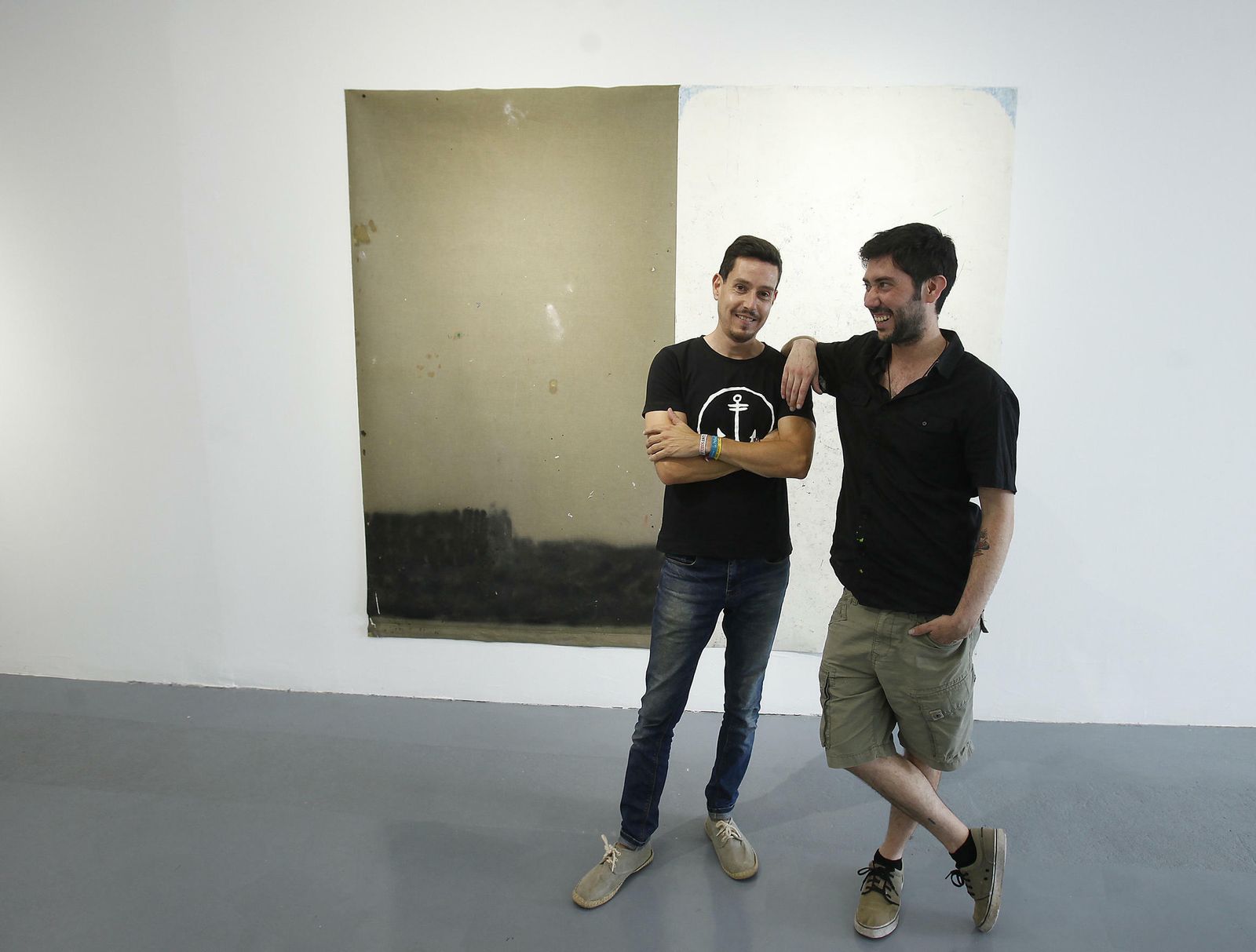 Santiago Bedoya (izquierda) y Juan Cruz, en la galería del Muro de los Navarros junto a una obra de Manuel M. Romero.