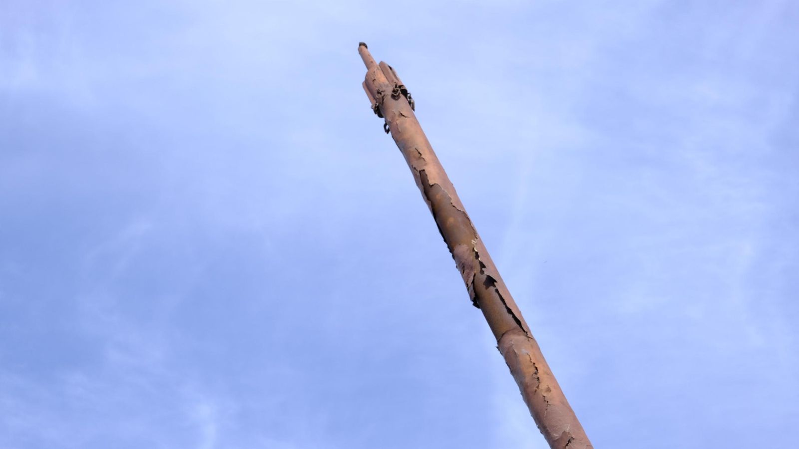 mástil oxidado.  Sin velas, inclinado y con riesgo de ser vencido por los vientos dado el elevado estado de corrosión que presenta.