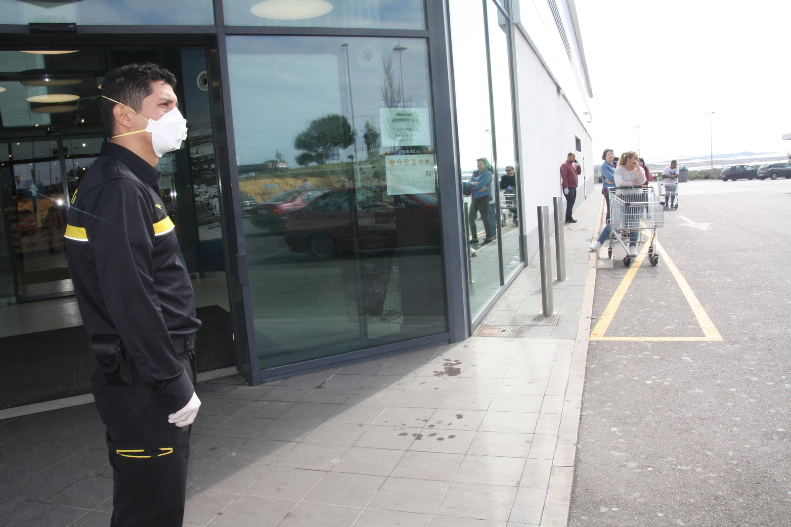 Un guardia de seguridad custodia la puerta de un supermercado en El Ejido.