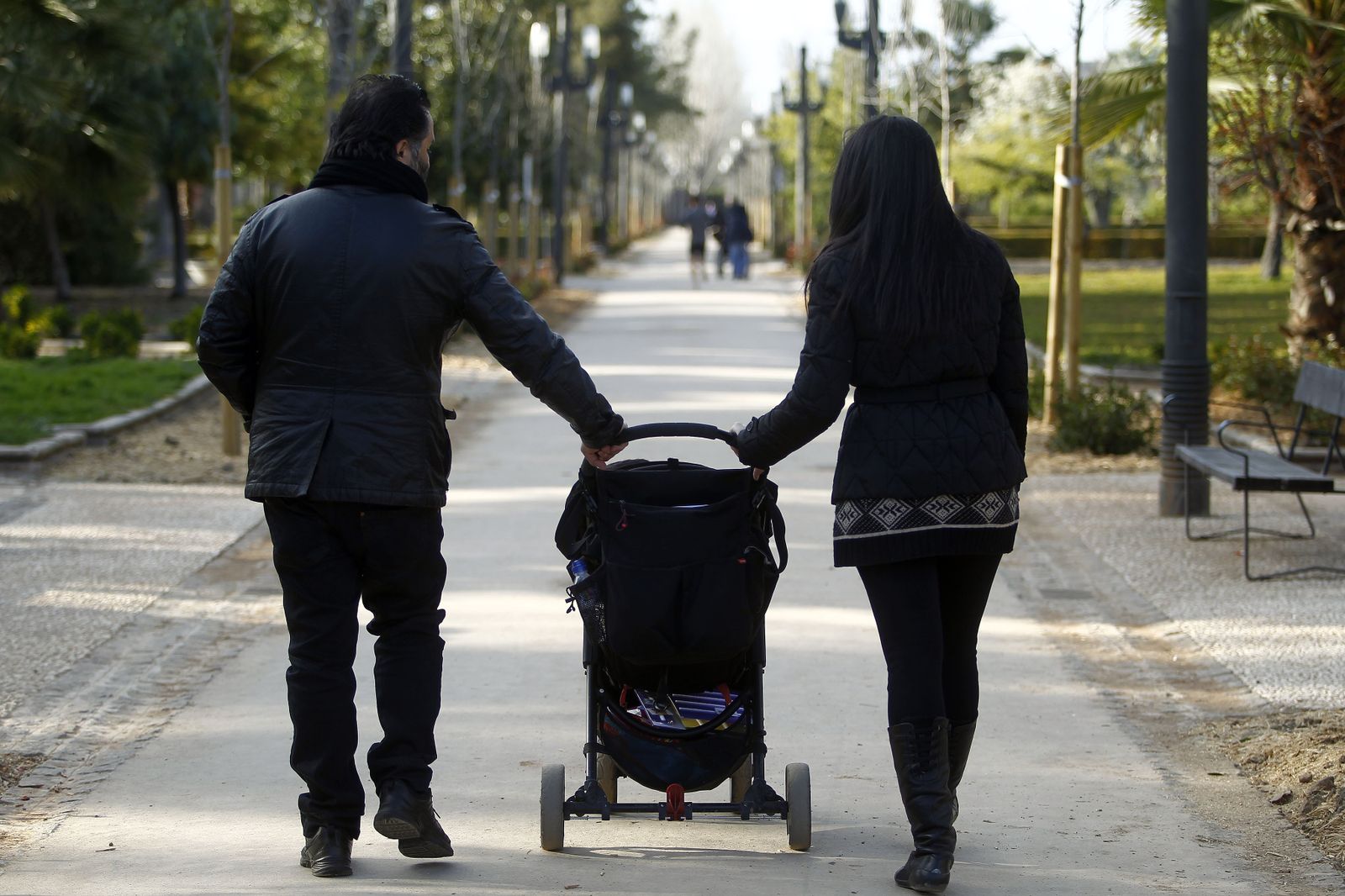 Una pareja pasea con su hijo.