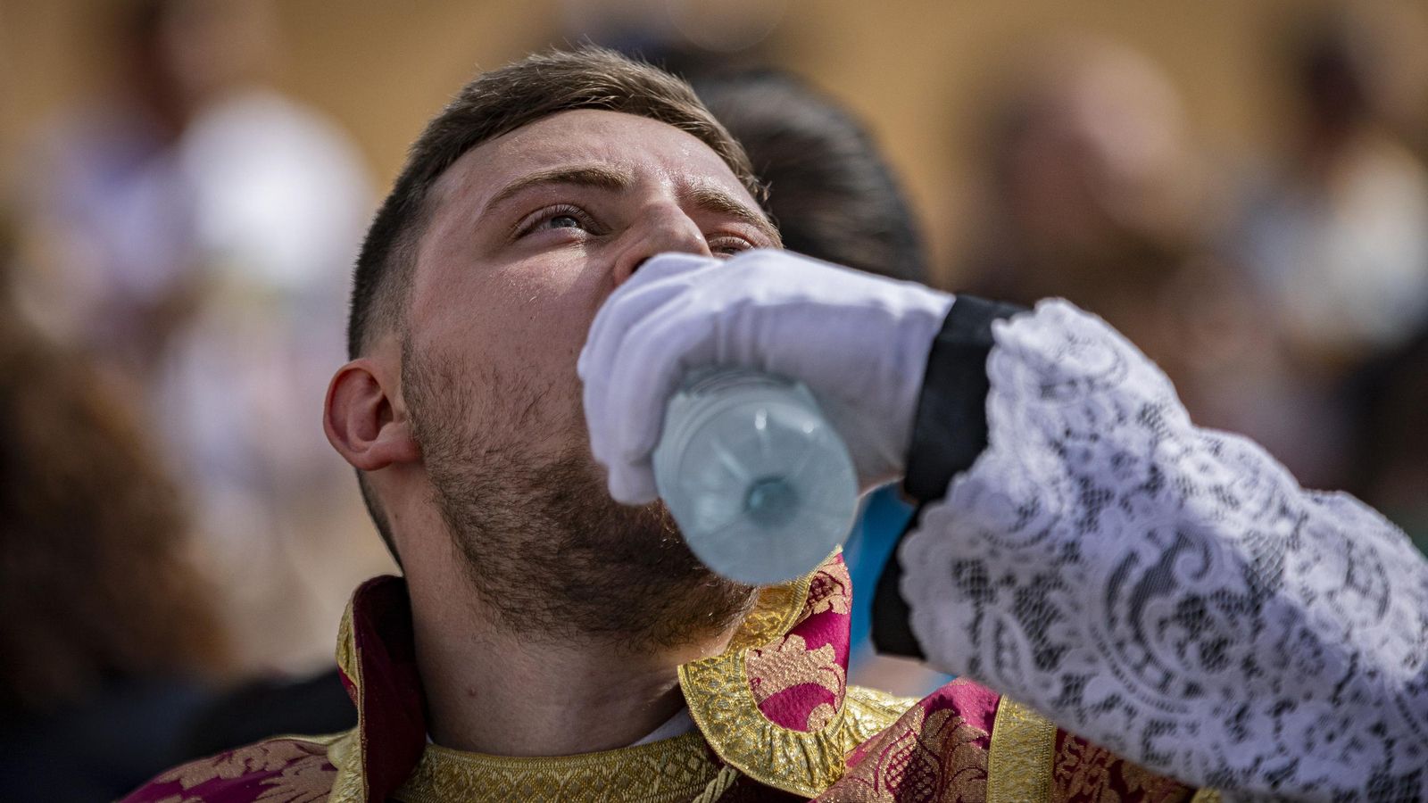 Un acólito de Humildad y Paciencia, en San Fernando, se refresca con agua en una tarde que deparó momentos de calor