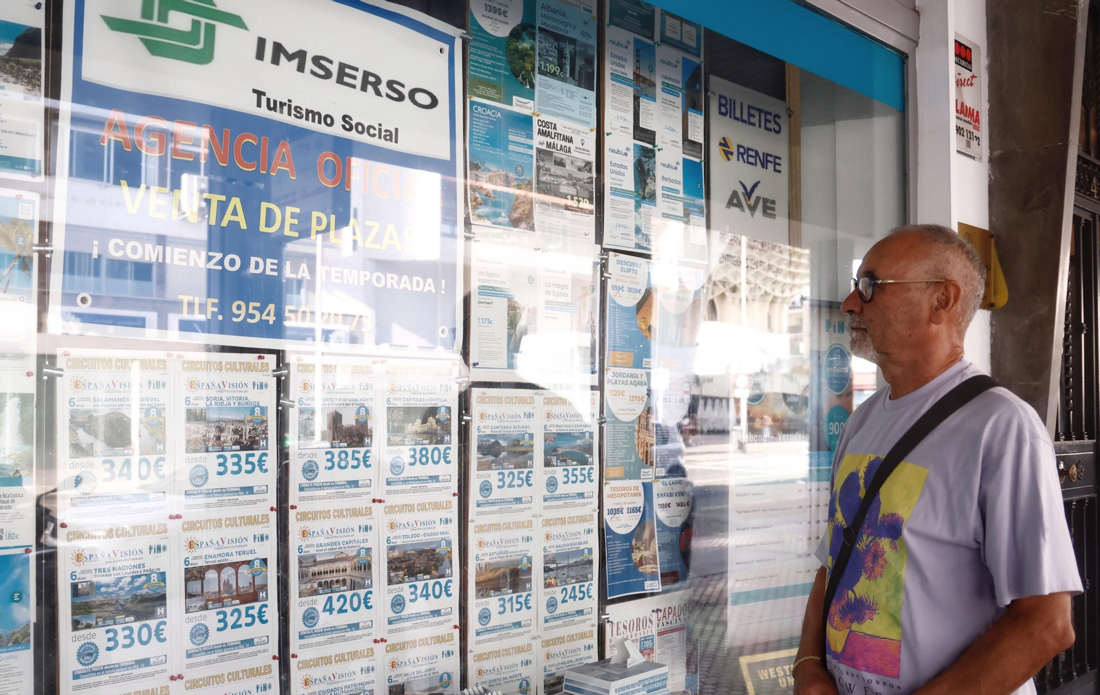 Una persona mira las ofertas de viajes del Imserso en una agencia.