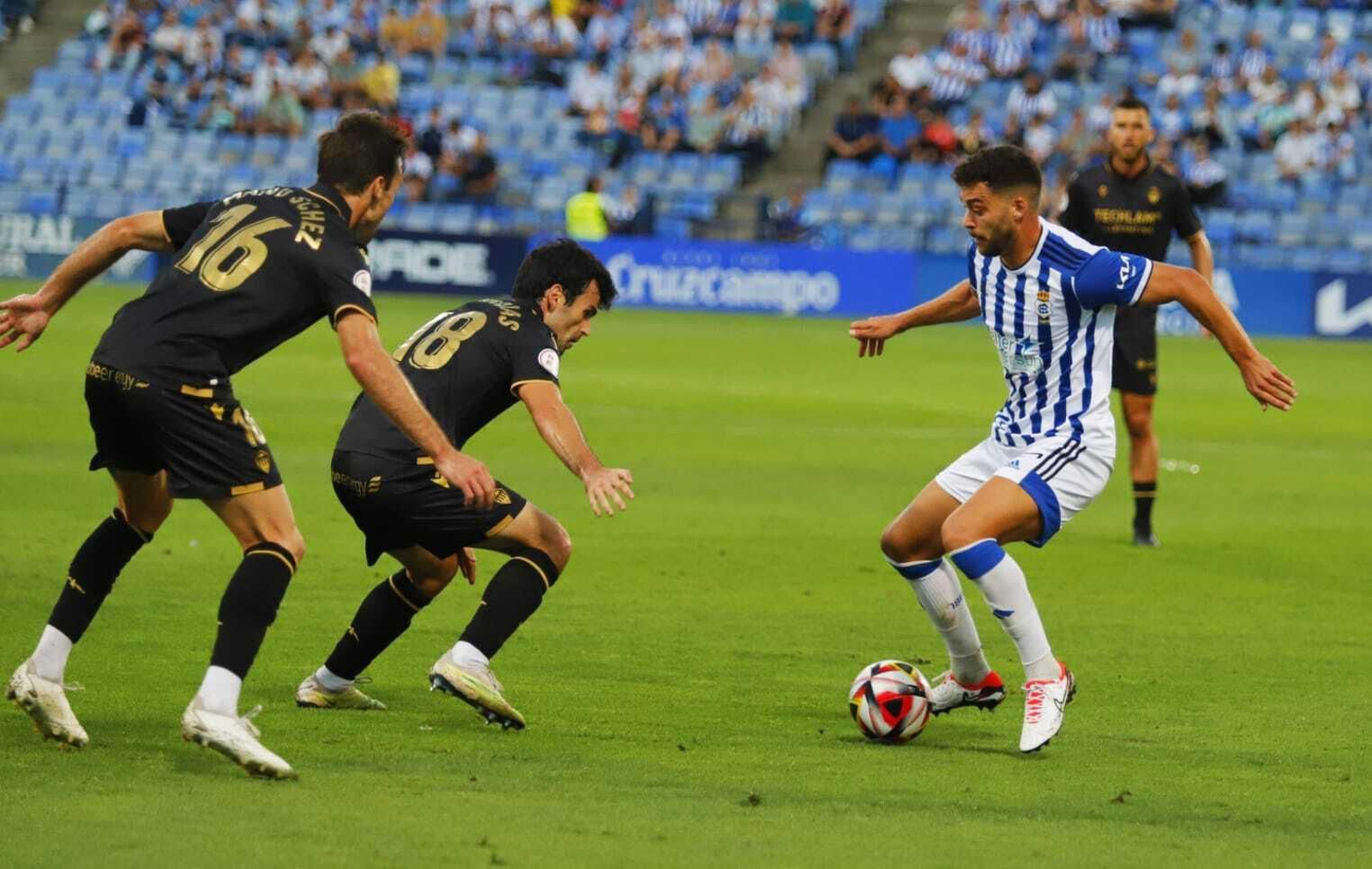 Manu Sánchez  e Iago Indias presionan a Luis Alcalde.