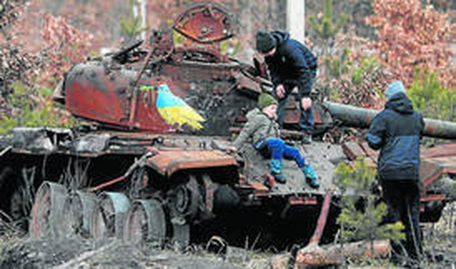 Unos niños ucranianos juegan en los restos de un tanque ruso cerca de Kiev.